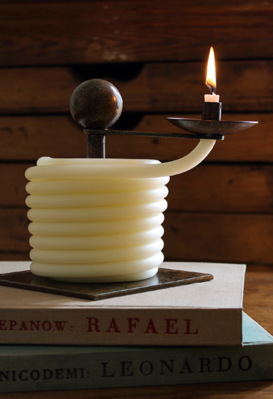 cream candle on stack of books