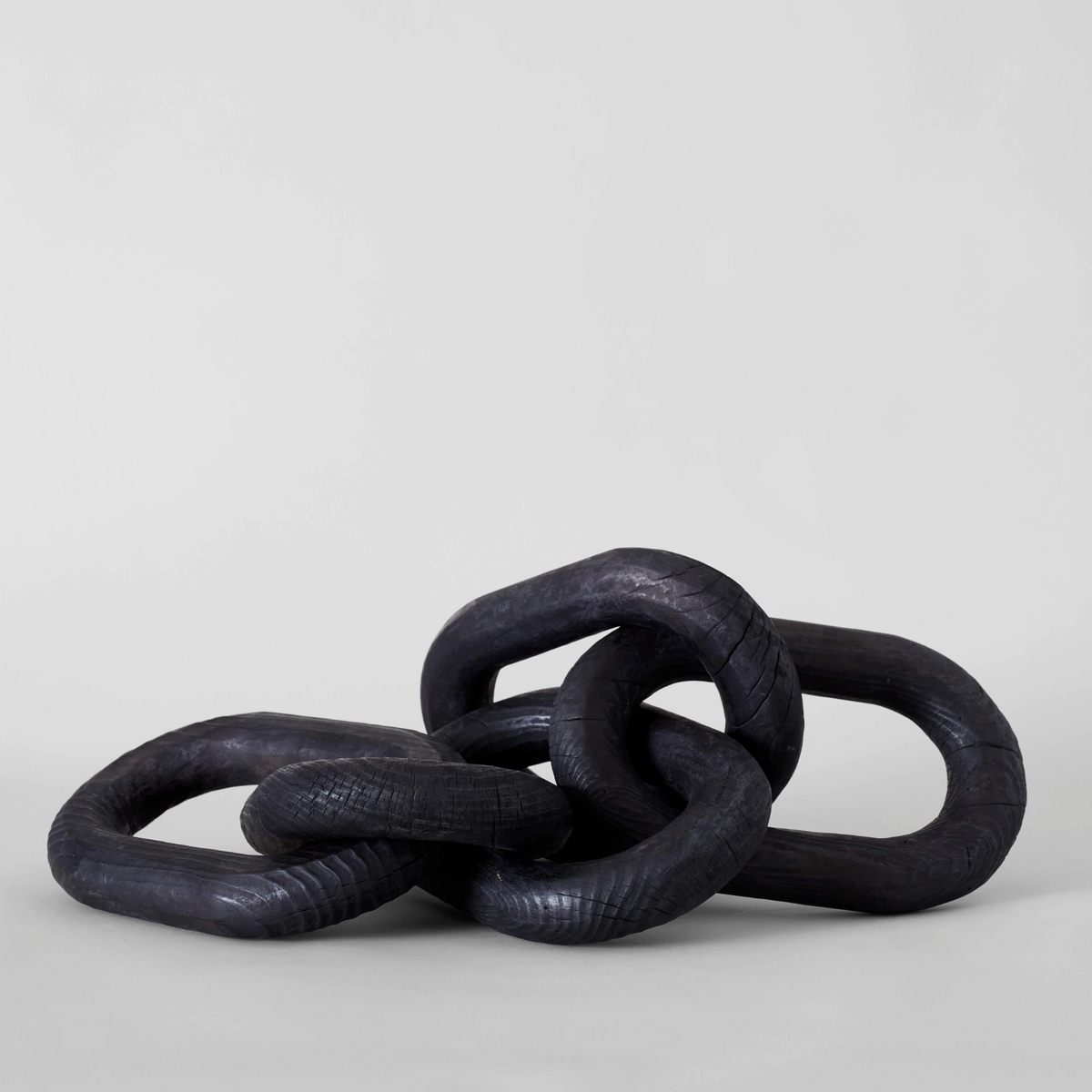 Three black rubber rings stacked on a light gray background