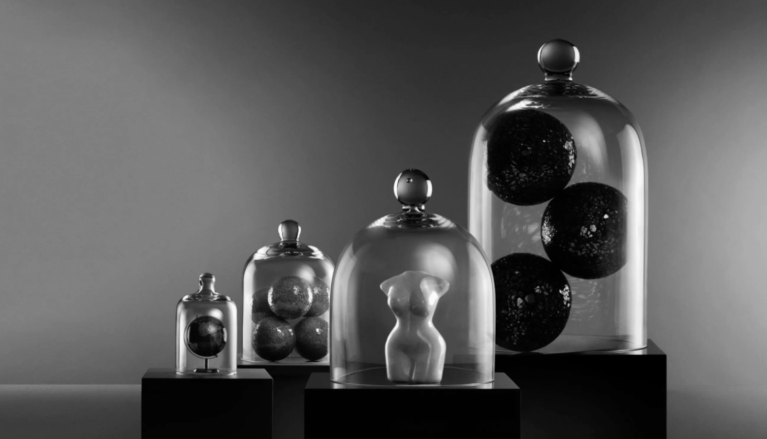 Collection of glass containers with spherical objects on a gray background