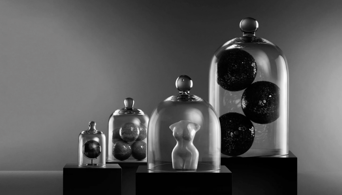 Collection of glass containers with spherical objects on a gray background