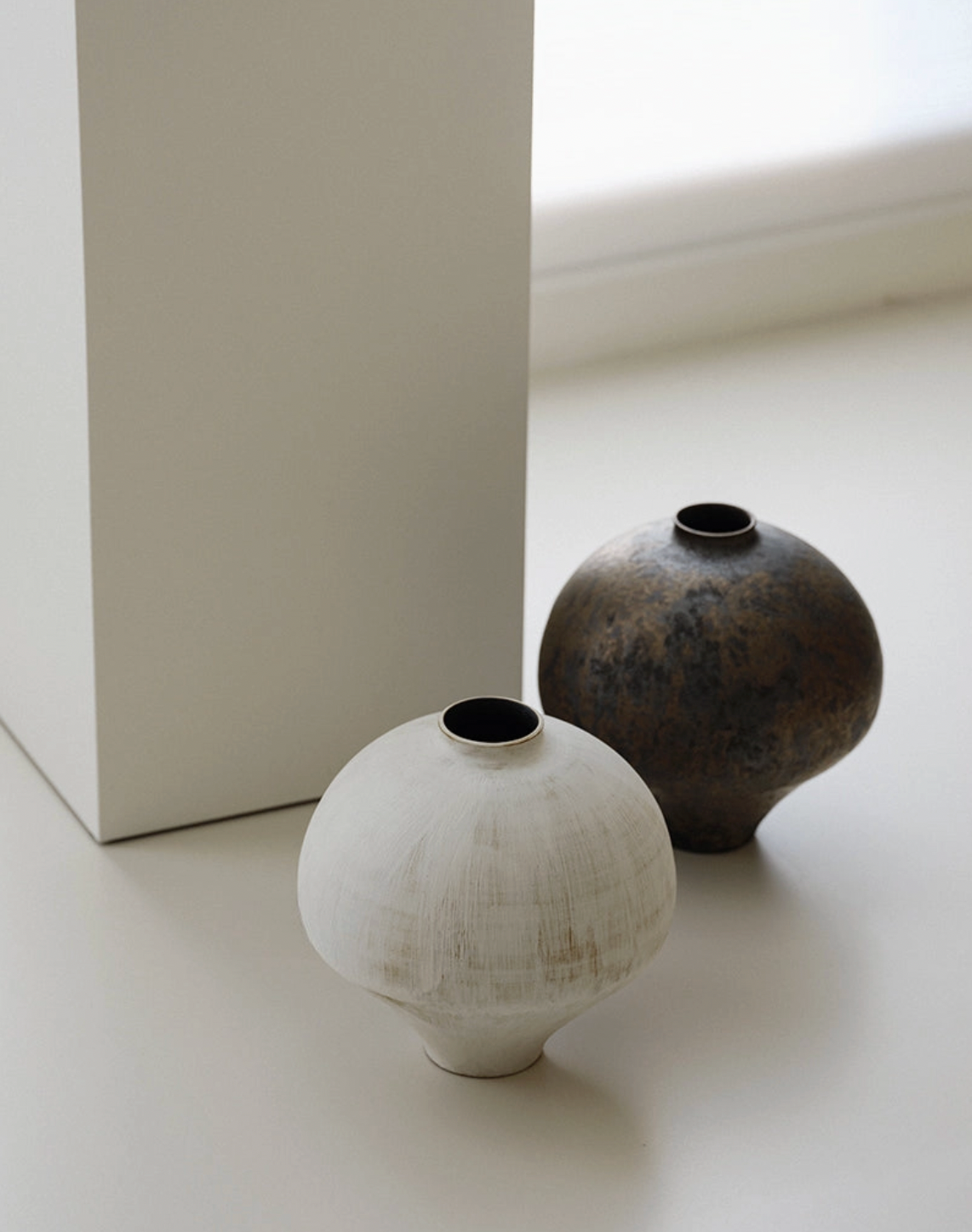 white and brown vase on white floor