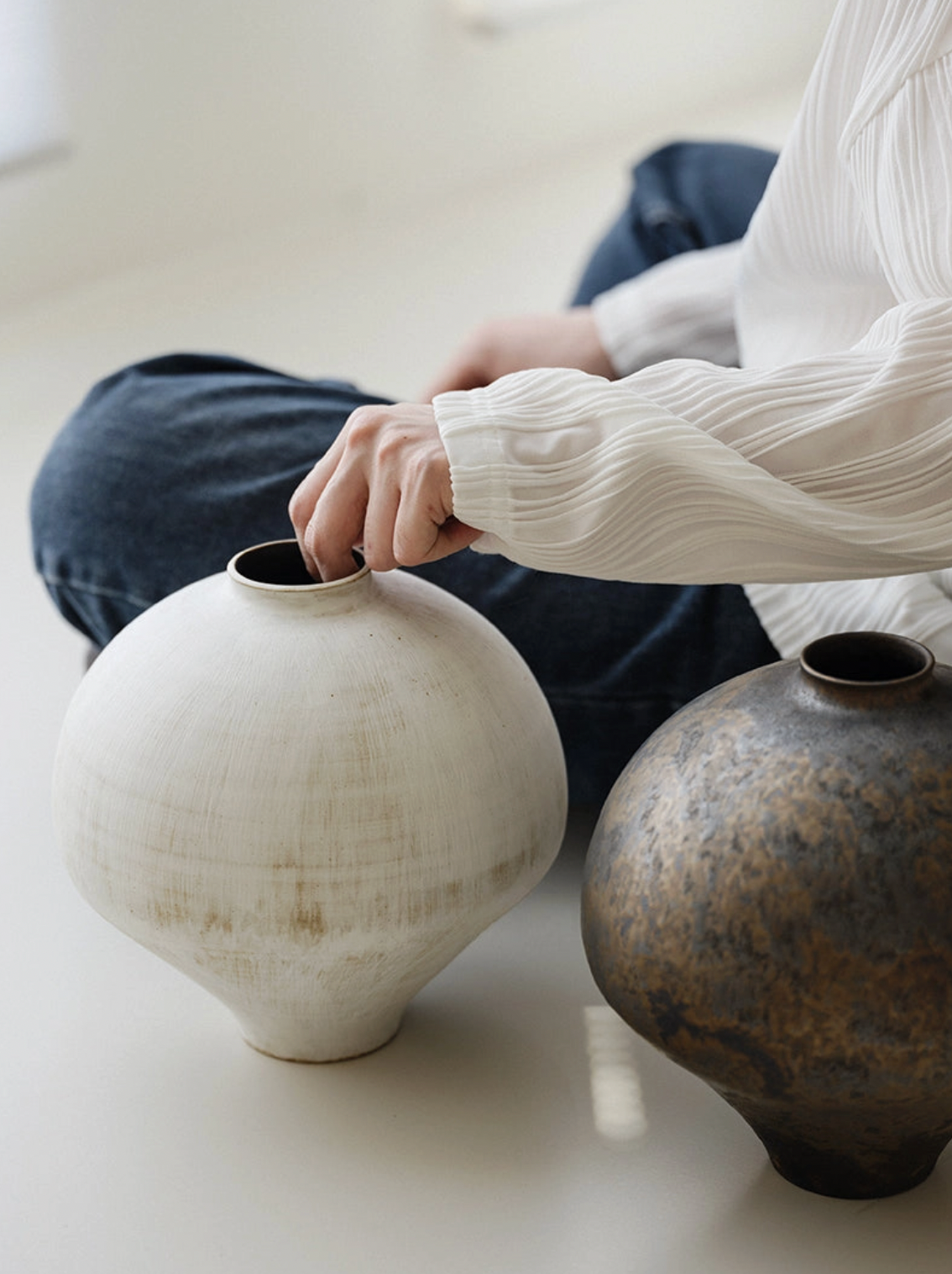 white and brown vase on white floor