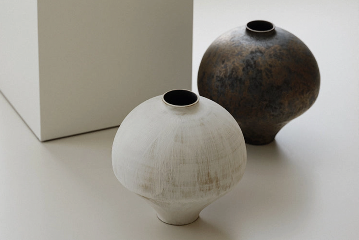 white and brown vase on white floor