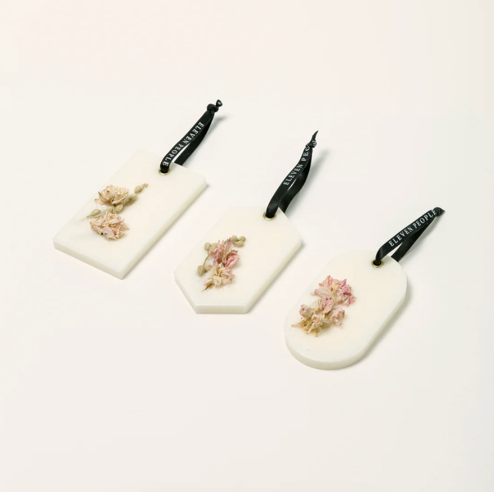 Three white scented wax bars with floral designs on a white background