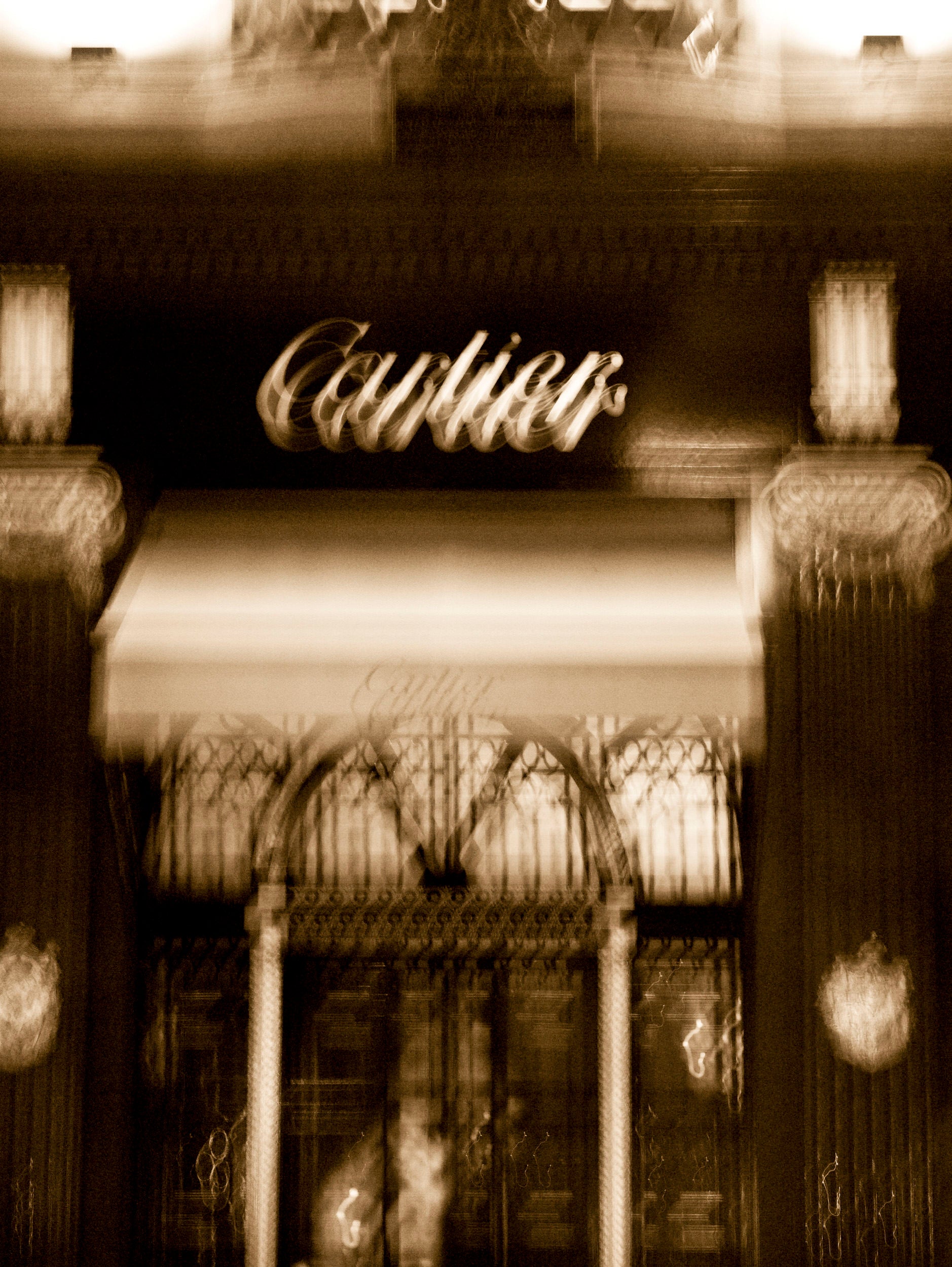 Vintage-style image of a building entrance with 'Cartier' sign