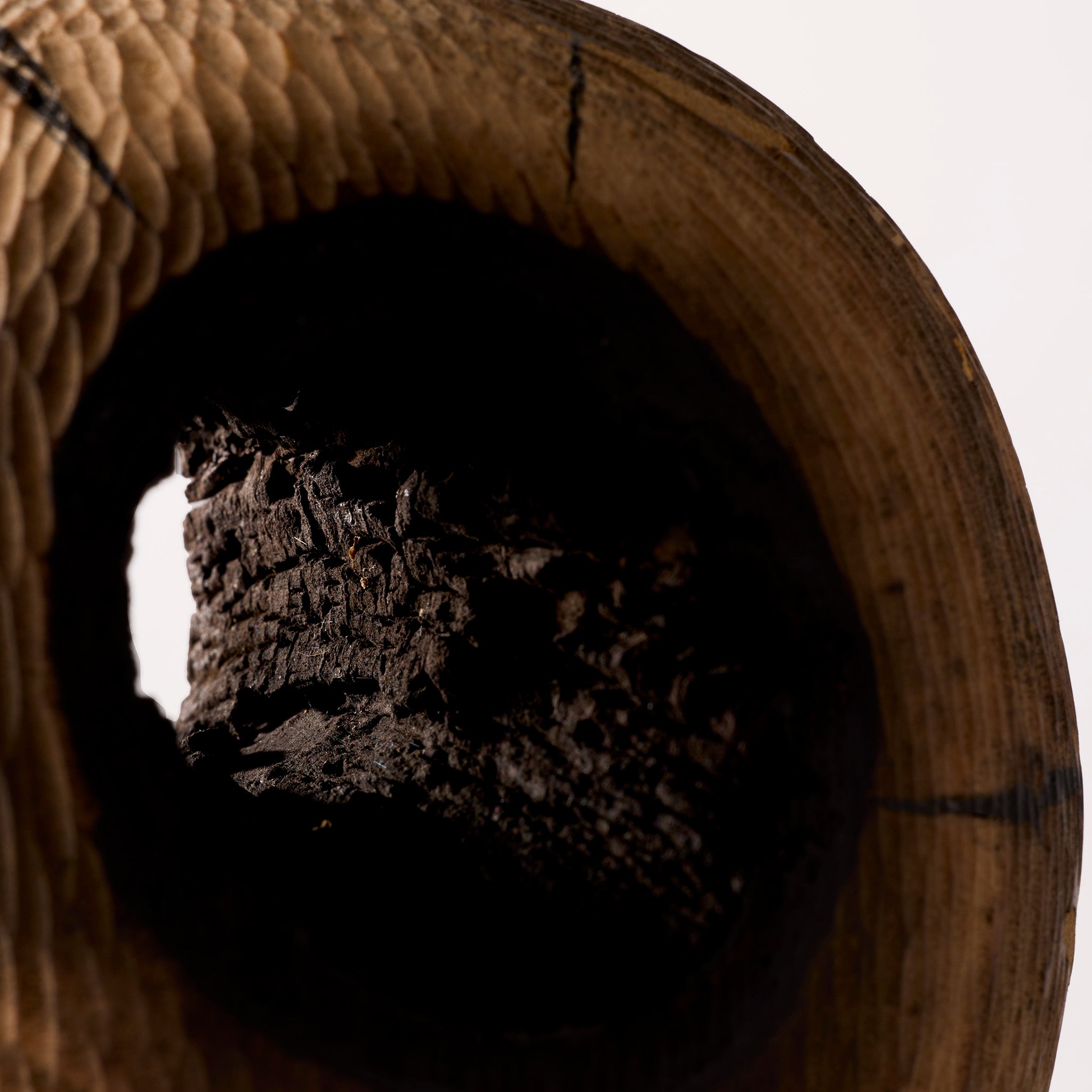 Close-up of a wooden vase with a dark interior