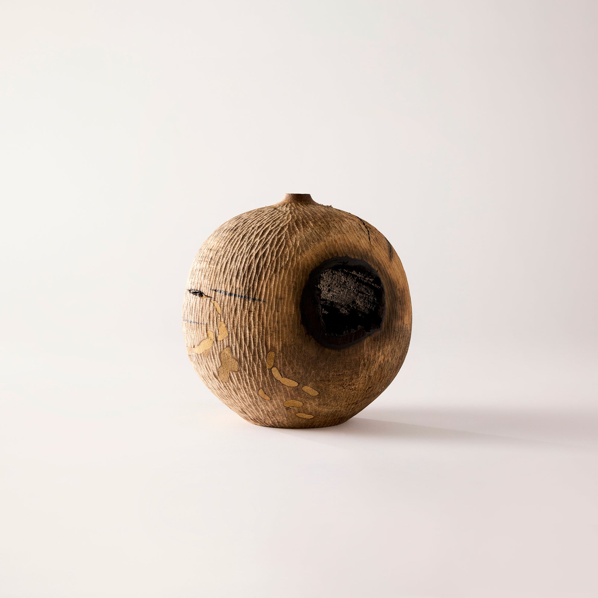 Wooden vase with a central hole on a white background