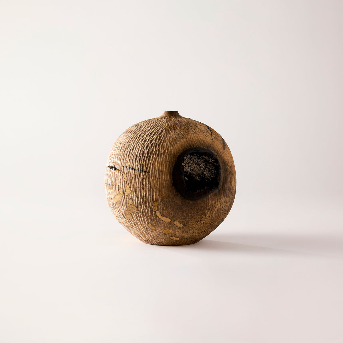 Wooden vase with a central hole on a white background