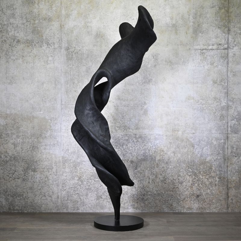 Black sculpture on wooden floor with black and white background