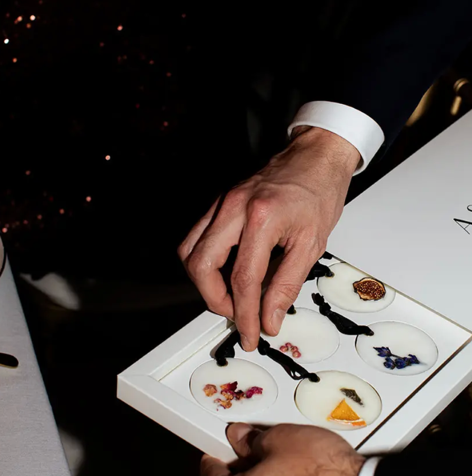 Person holding a box of small dishes with food samples