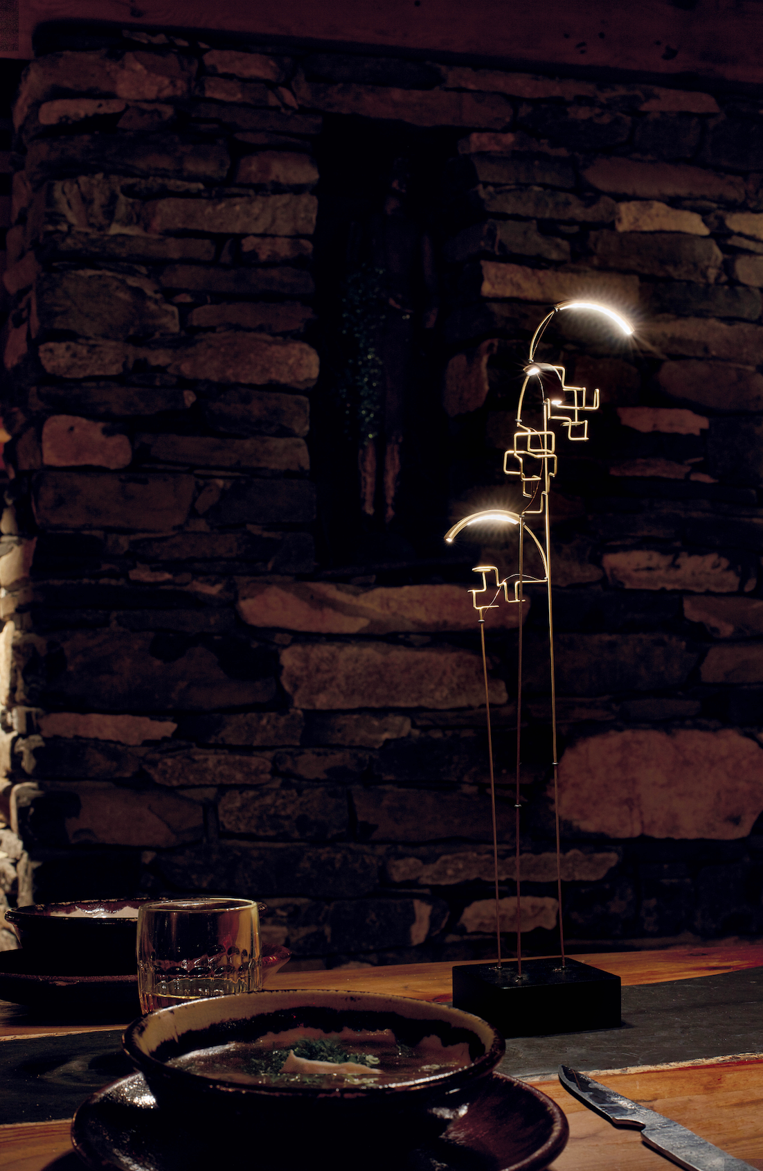 Decorative lamp with abstract design on a stone wall background