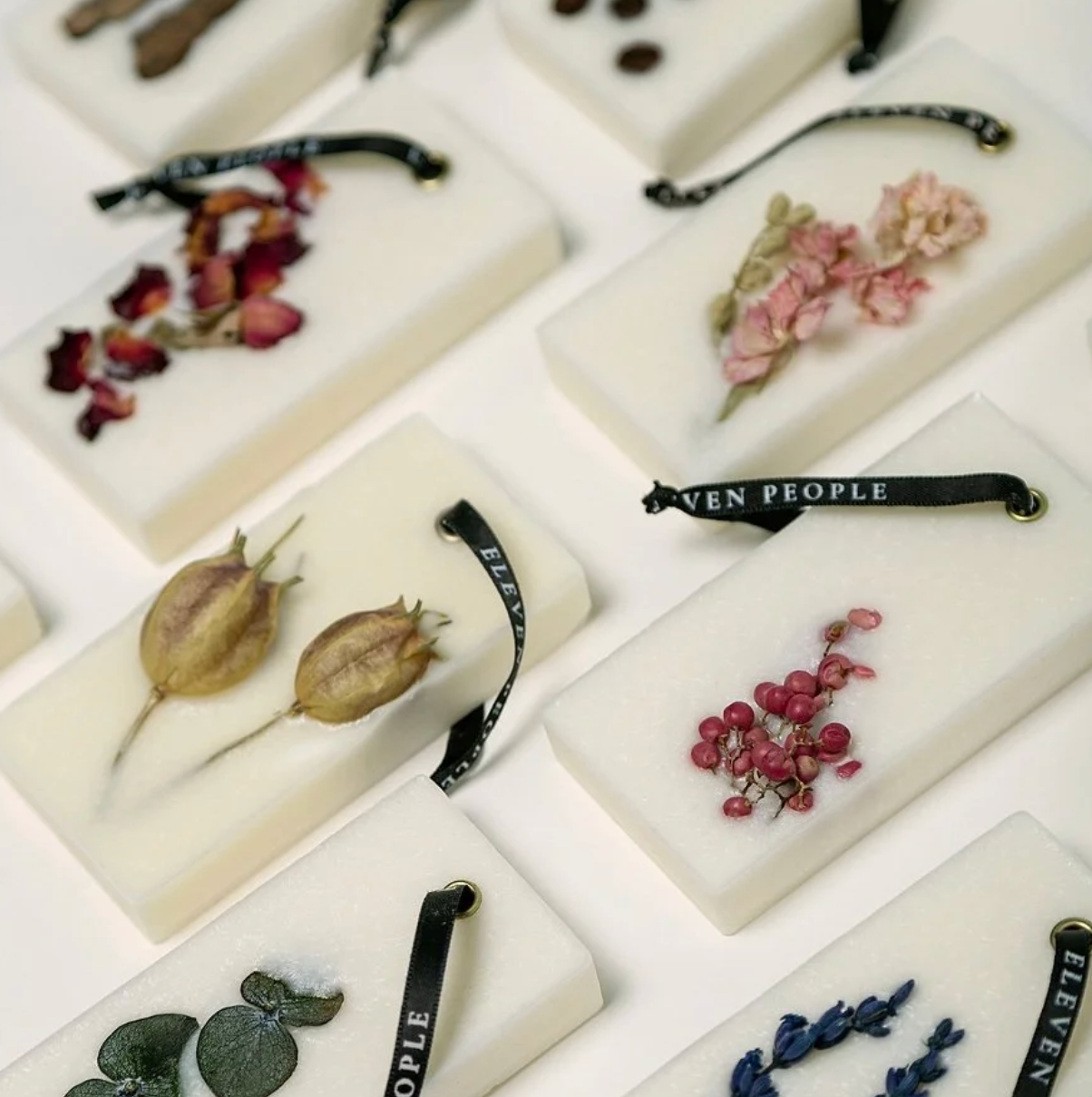 Collection of soap bars with embedded botanical elements on a white background