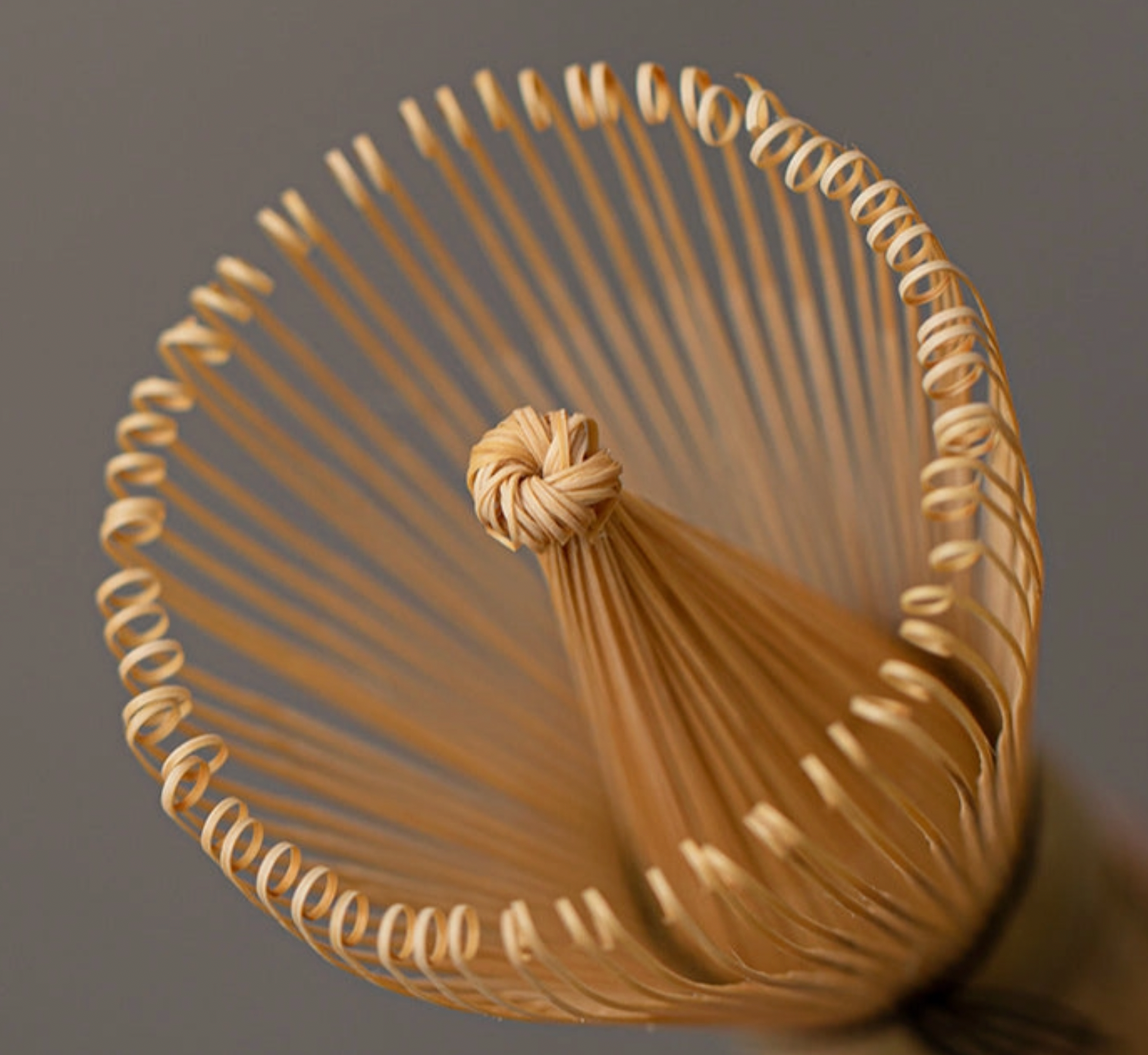 Bamboo whisk with a tassel on a gray background
