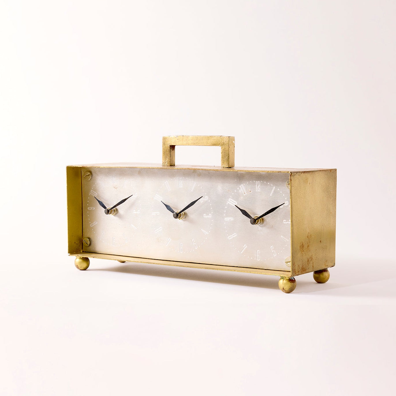 Gold clock on white background with three faces