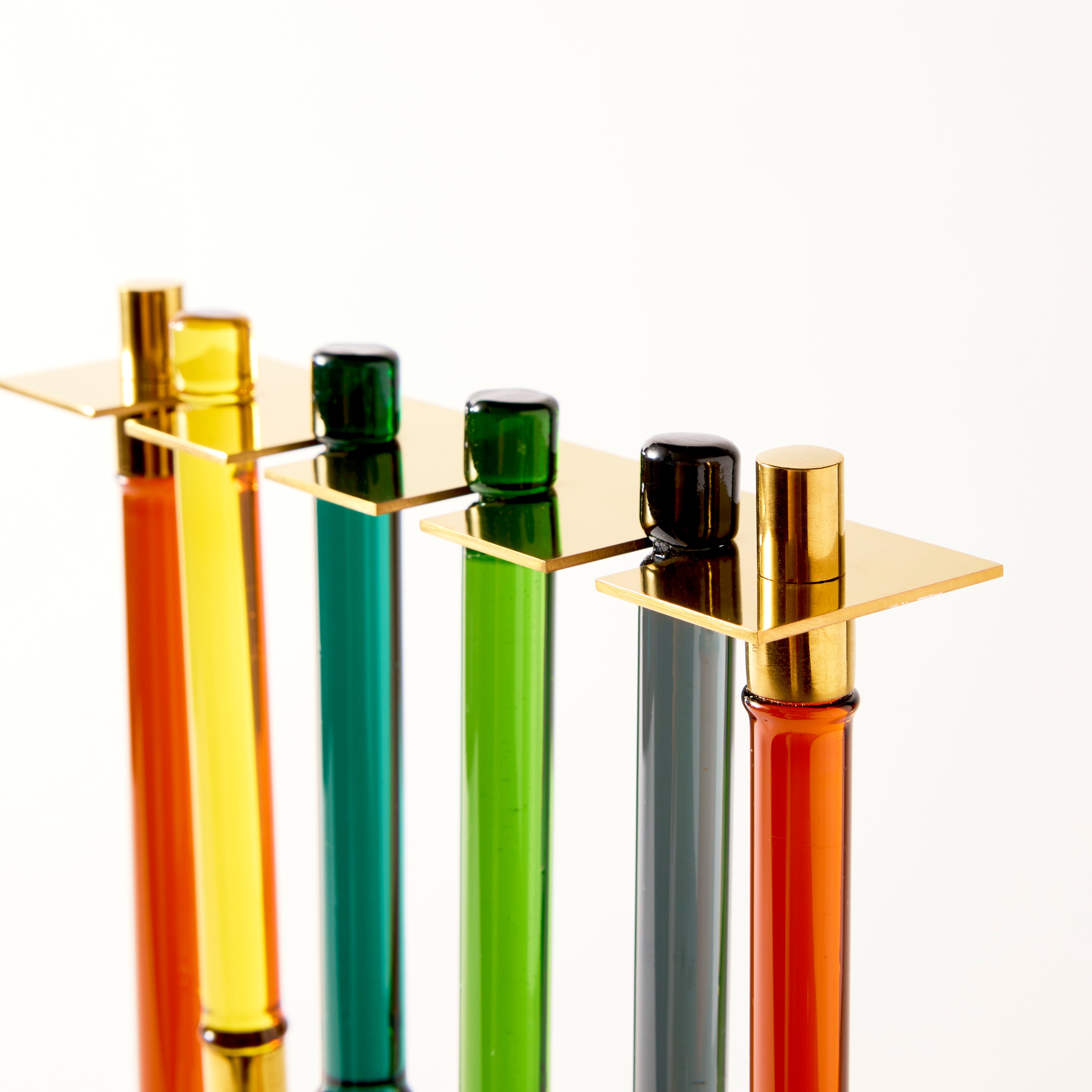 Five colorful test tubes with gold caps on a white background