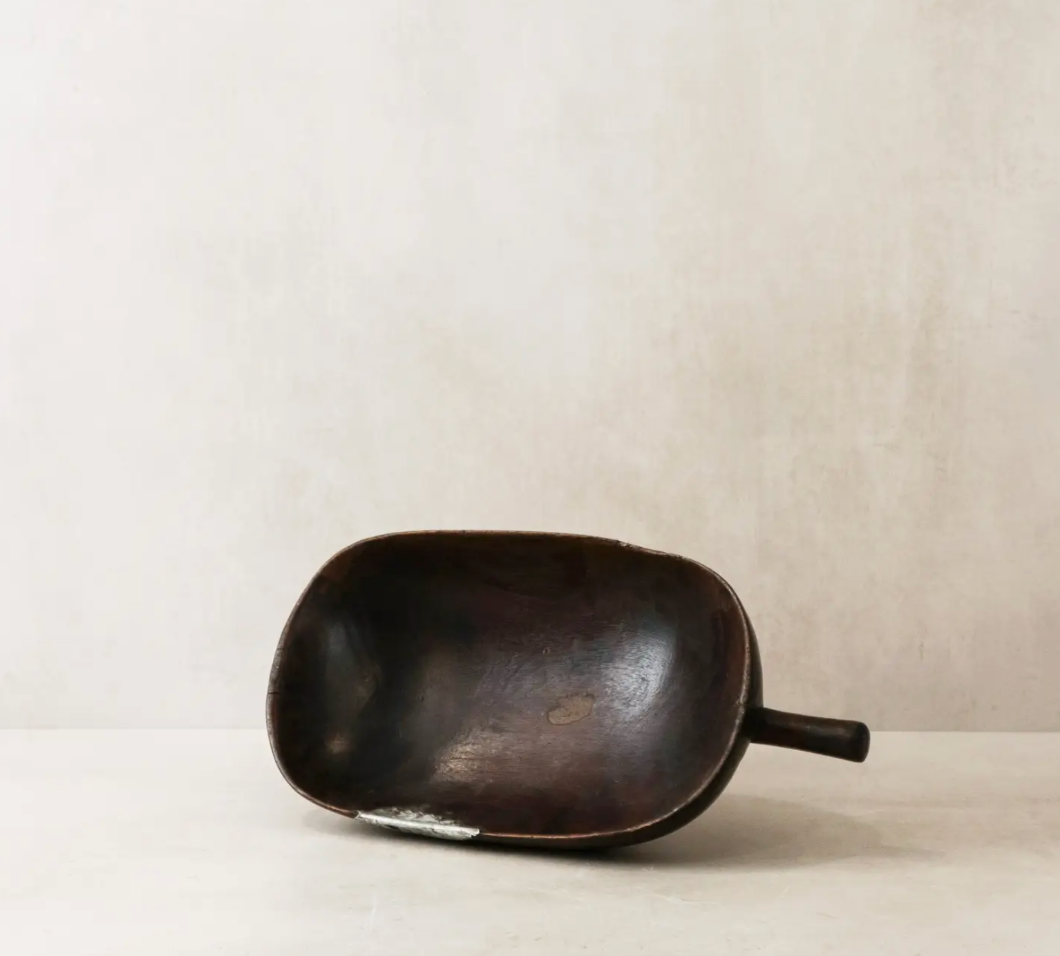 Black ceramic scoop on a beige background