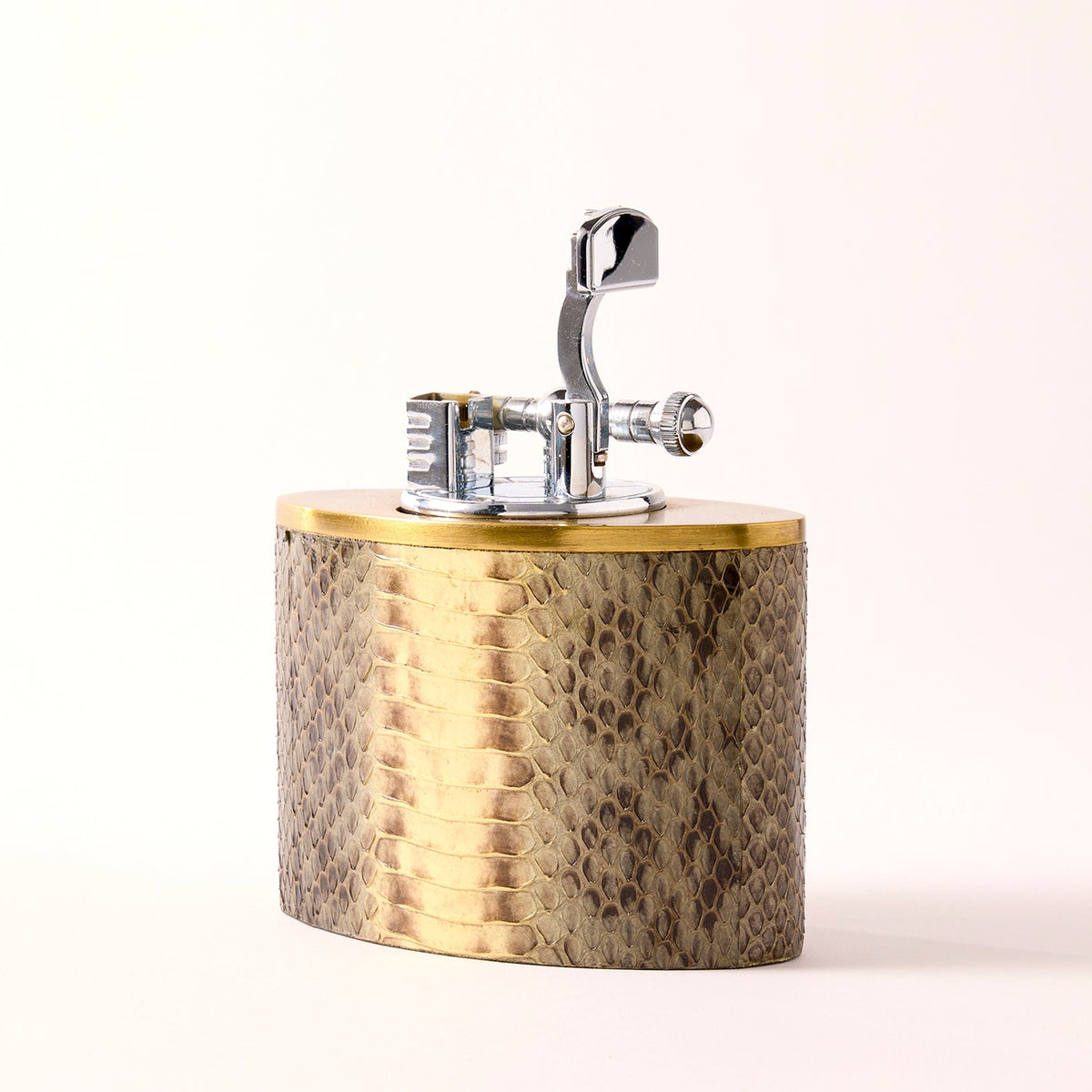 Oval oversized lighter in snakeskin with brass accent, front view