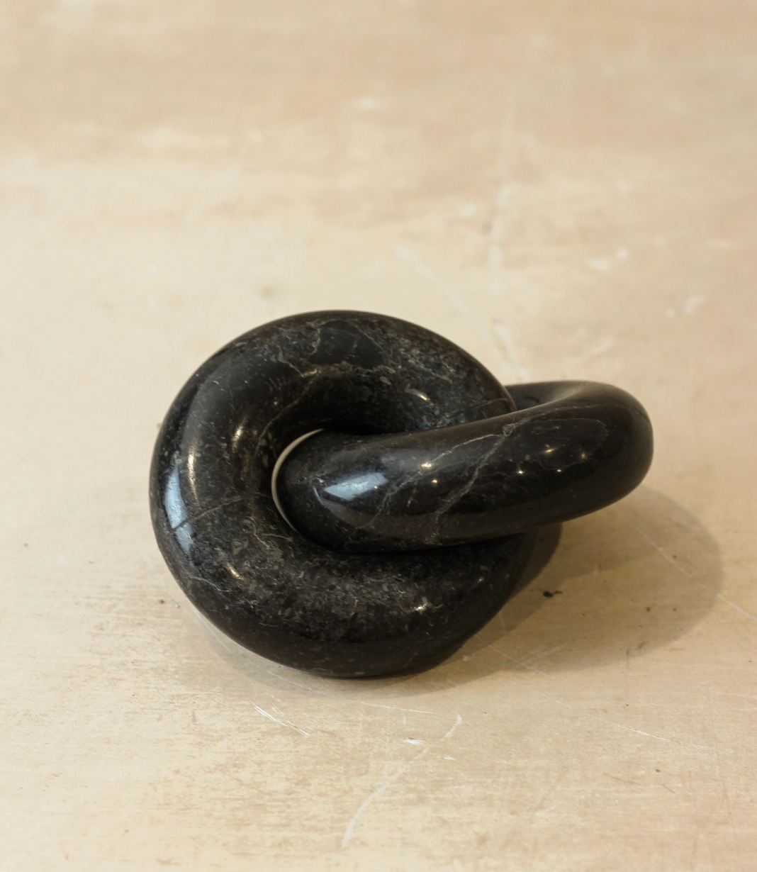 Black stone knot on a beige surface