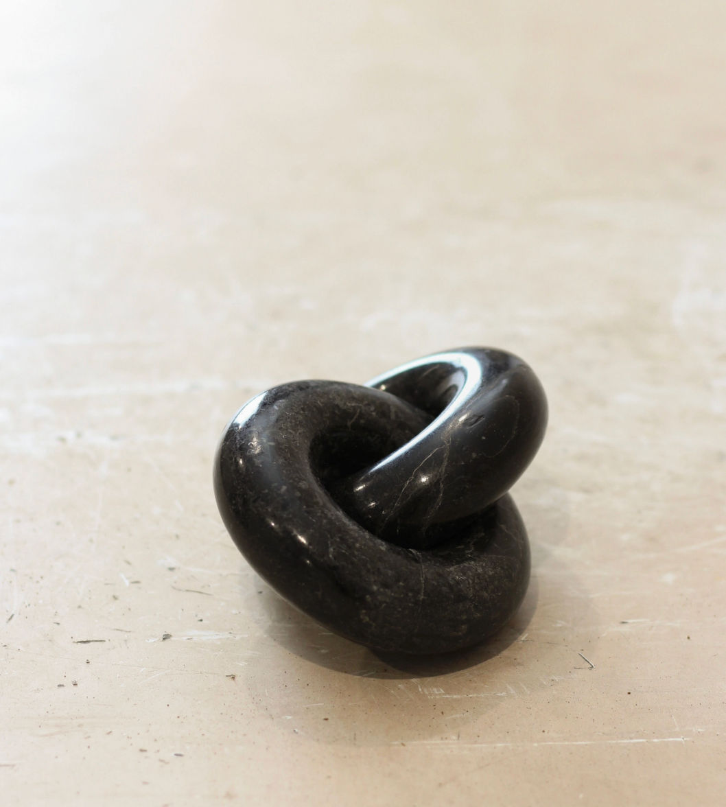 Black stone with a unique shape on a beige surface