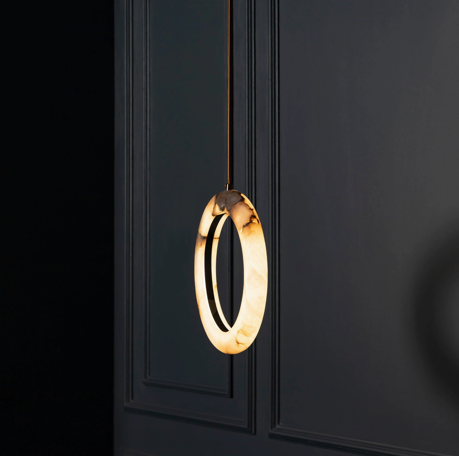 Modern pendant light with circular design on a black background