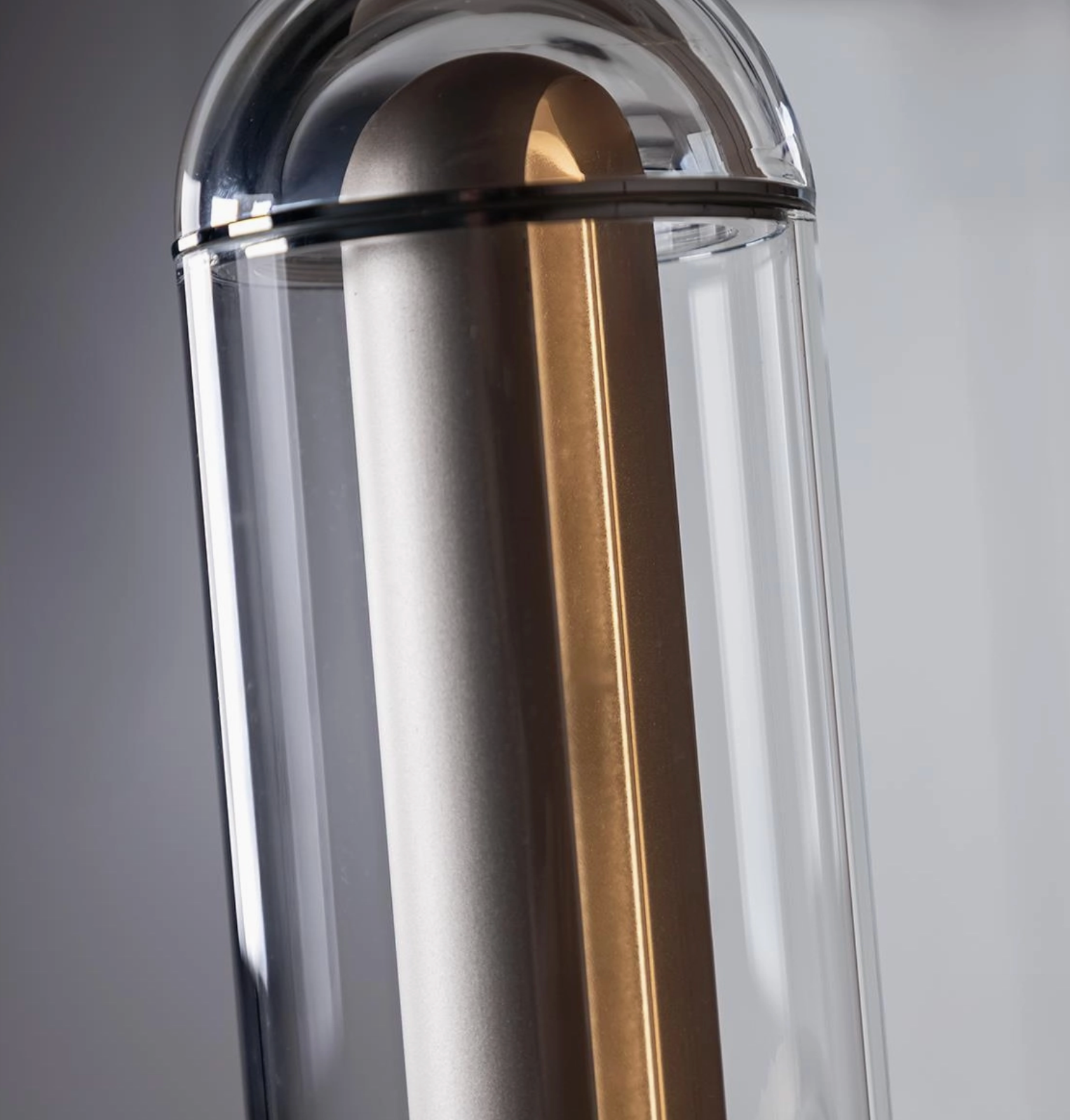 Close-up of a cylindrical object with metallic finish on a gray background