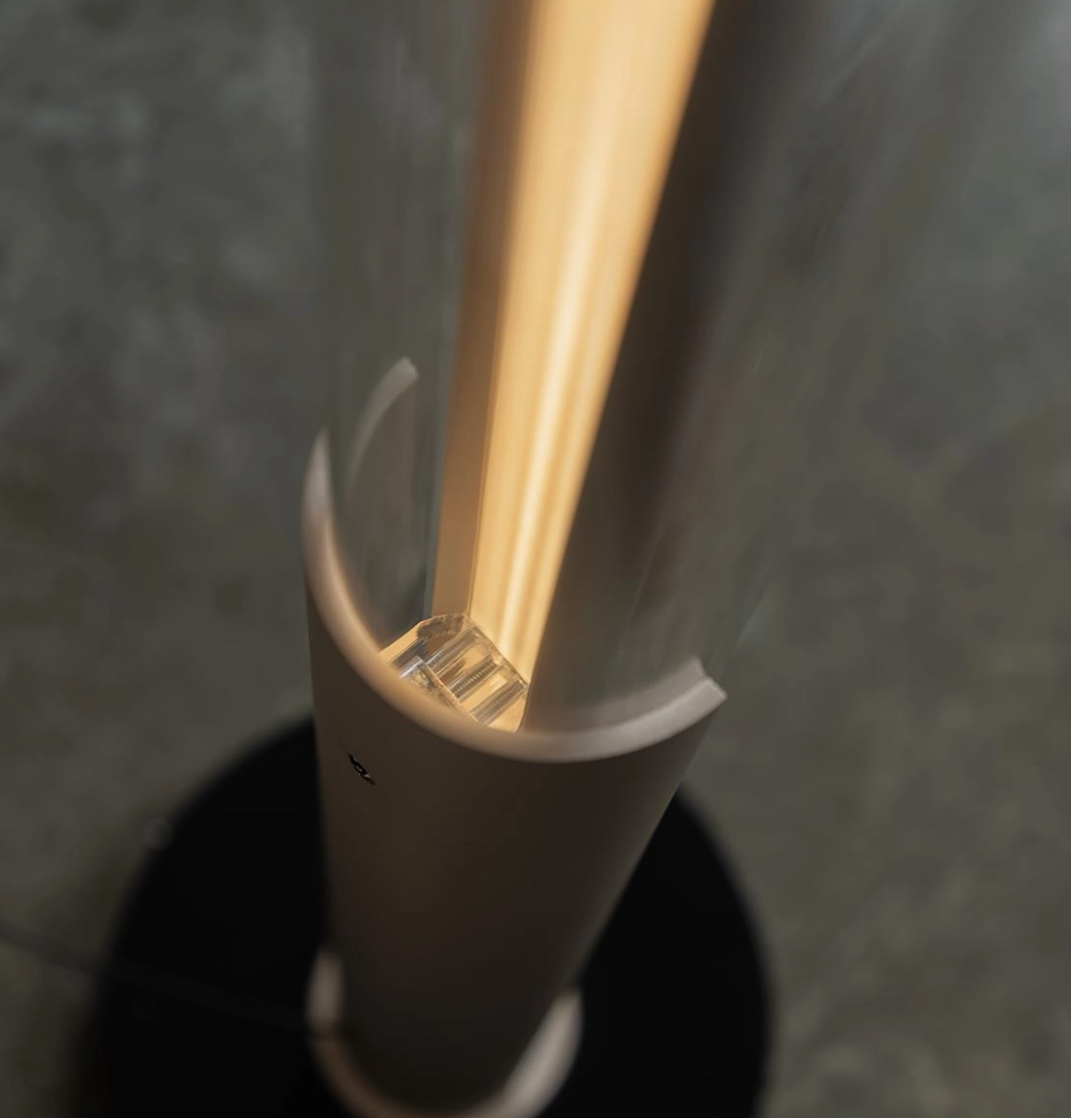 Close-up of a white cup with a beige straw against a dark background