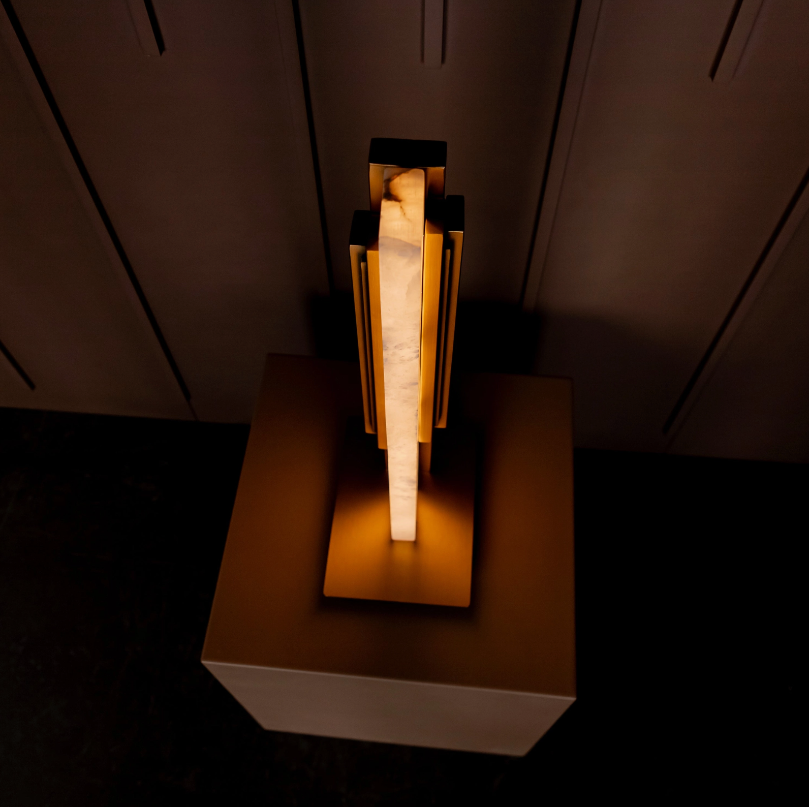 Modern table lamp with a wooden base and metallic accents on a dark surface.