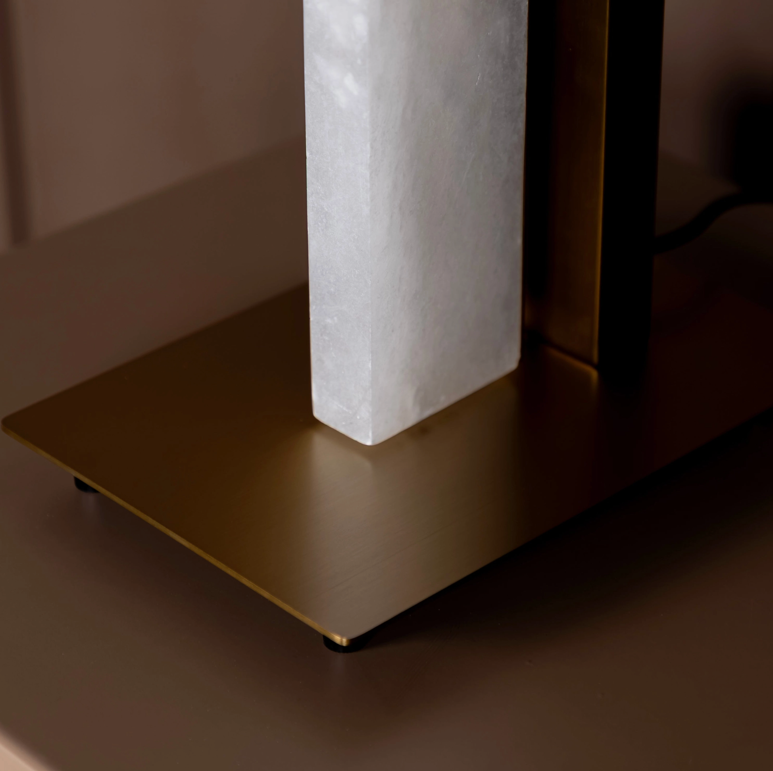 Close-up of a modern table lamp with a marble-like shade on a dark surface.