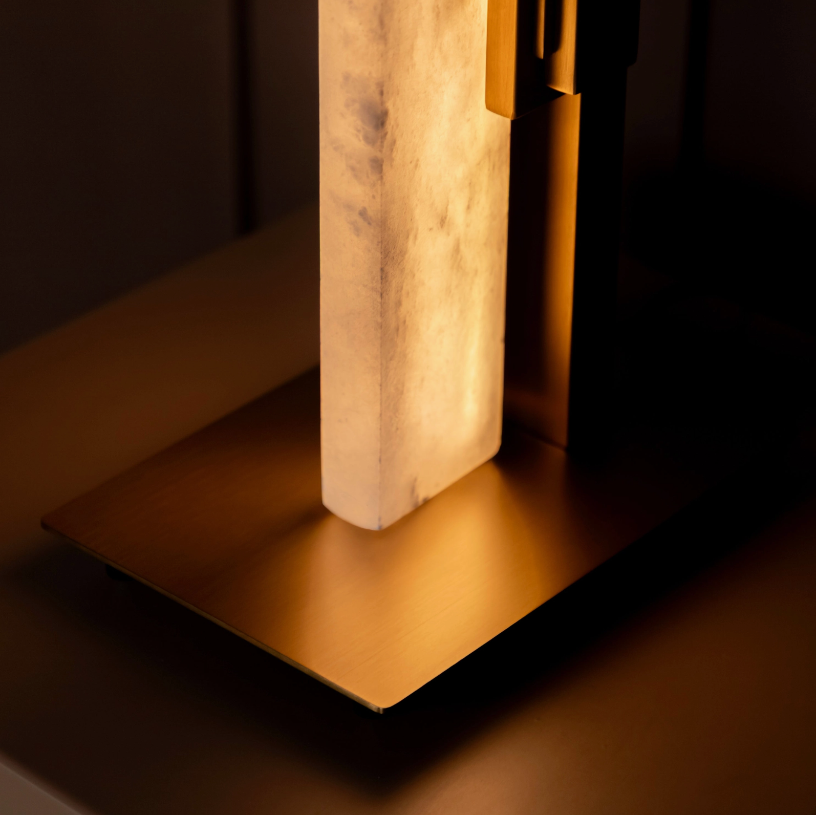 Decorative lamp with marble base and gold accents on a dark background