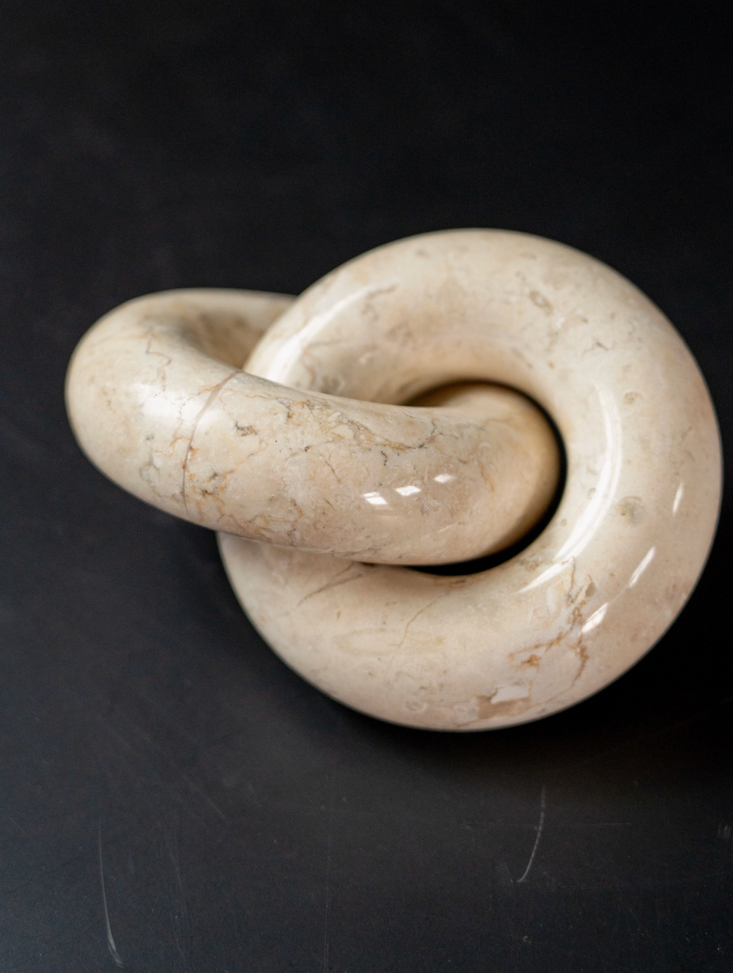 White stone knot sculpture on a black background