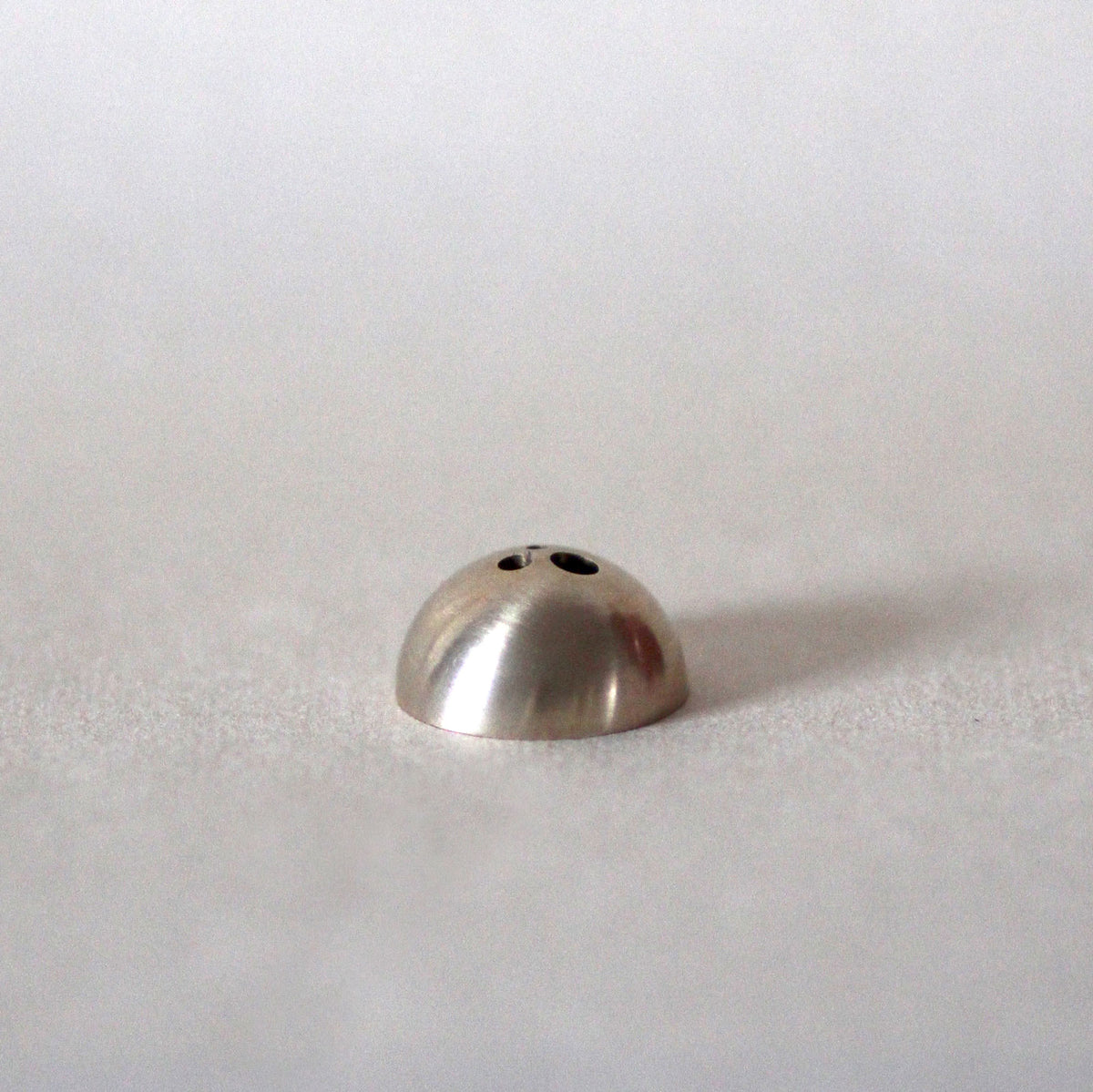 Metallic dome-shaped object on a white background