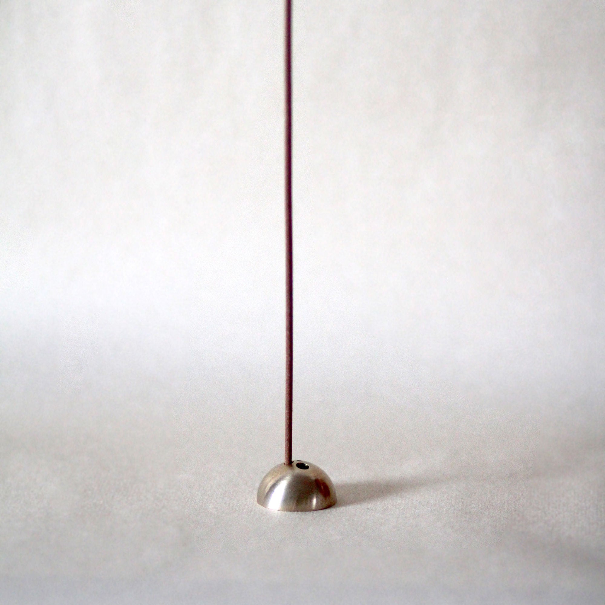 Metallic floor lamp with a long thin neck on a white background