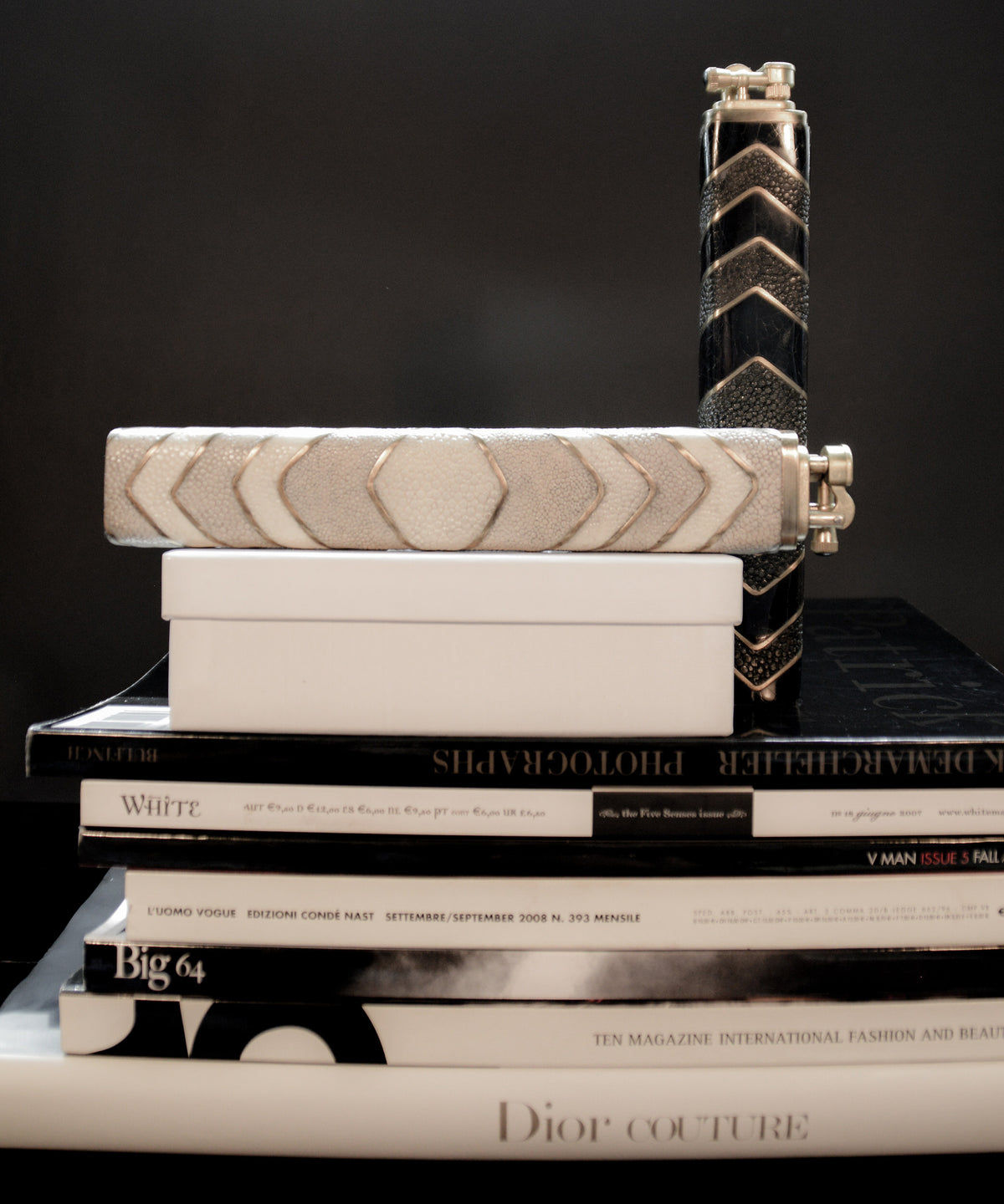 Stack of books with a decorative object on top against a dark background