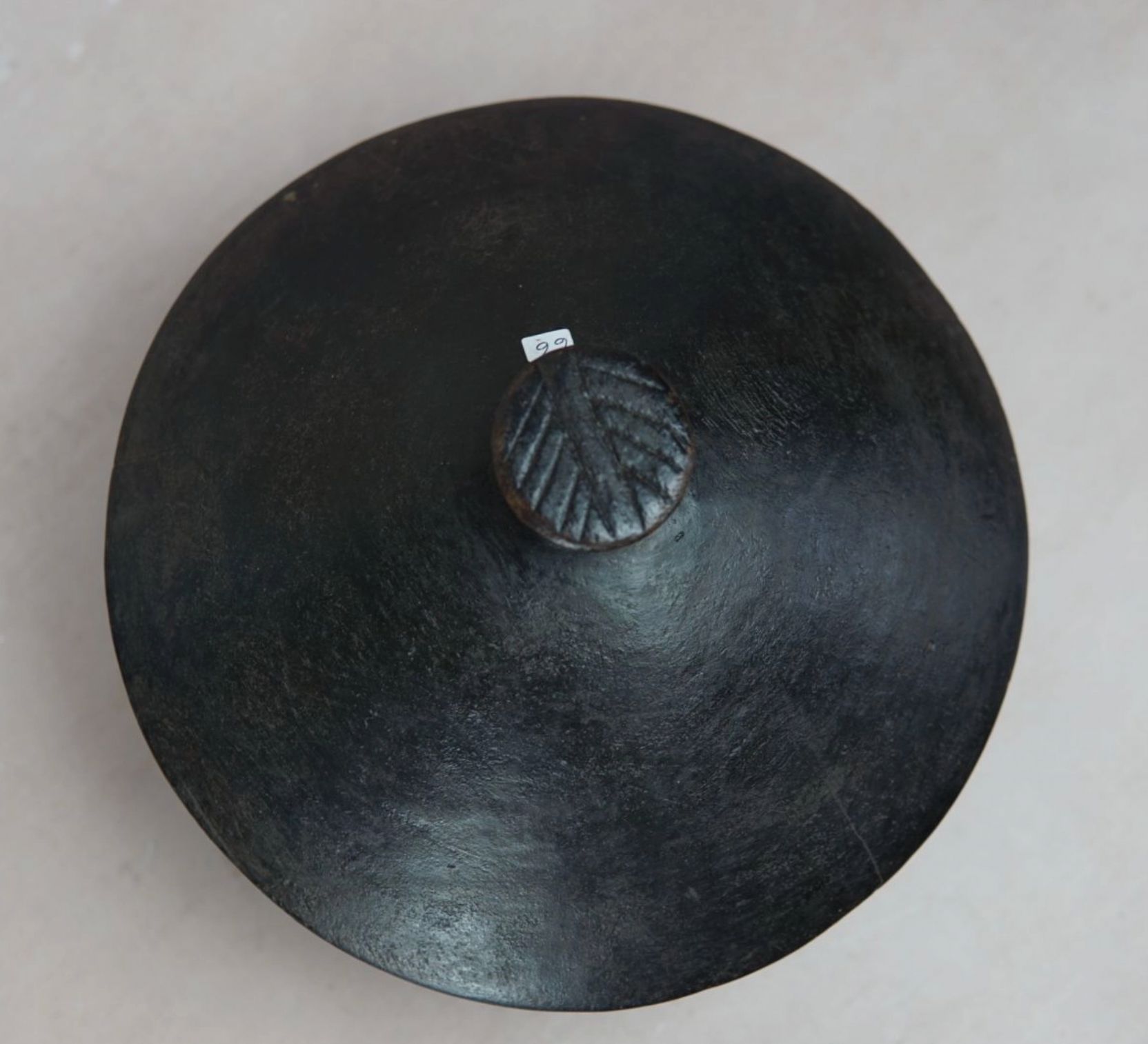 Black ceramic dish with lid on a light gray background