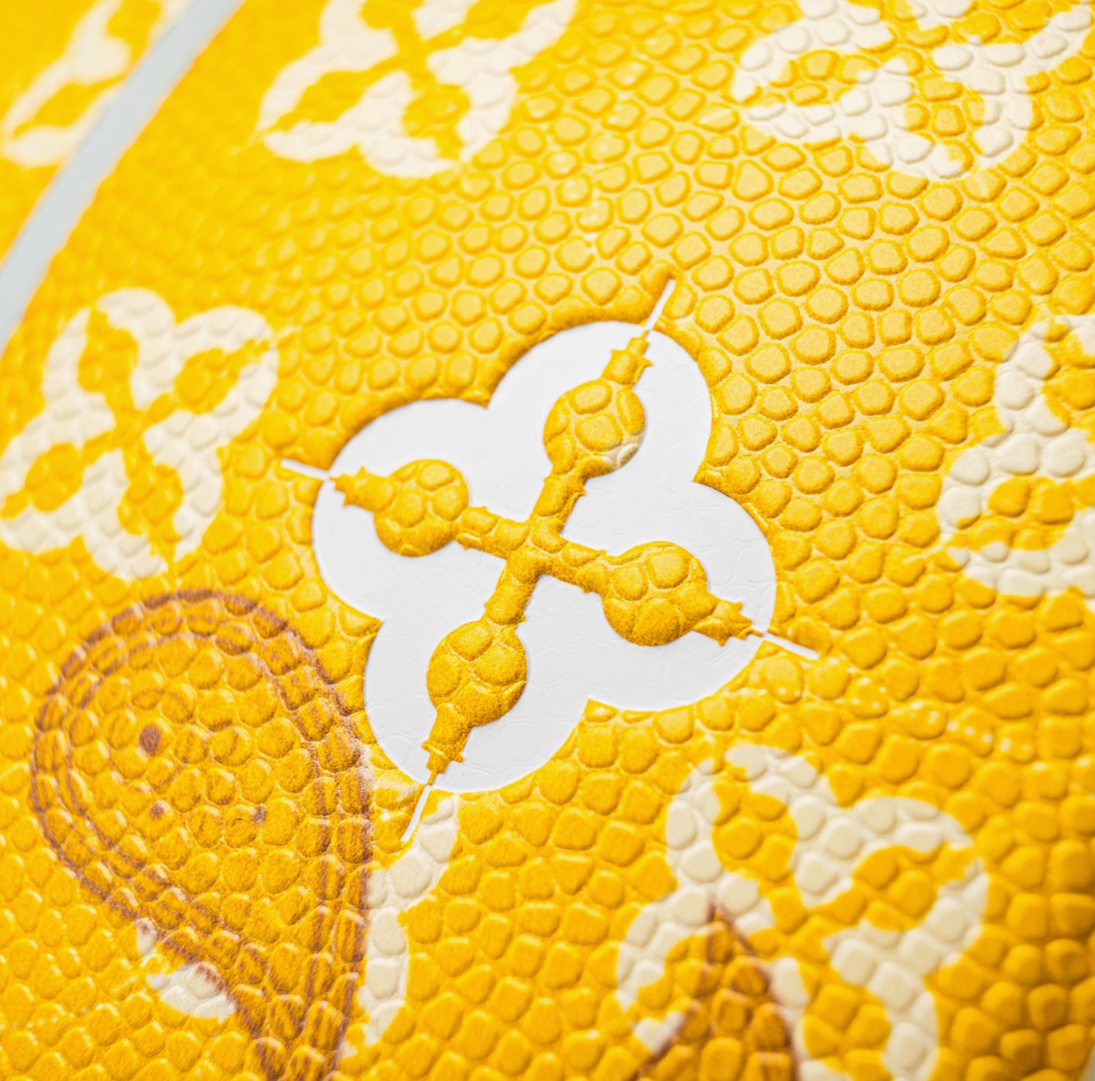 Close-up of a textured yellow surface with white floral patterns