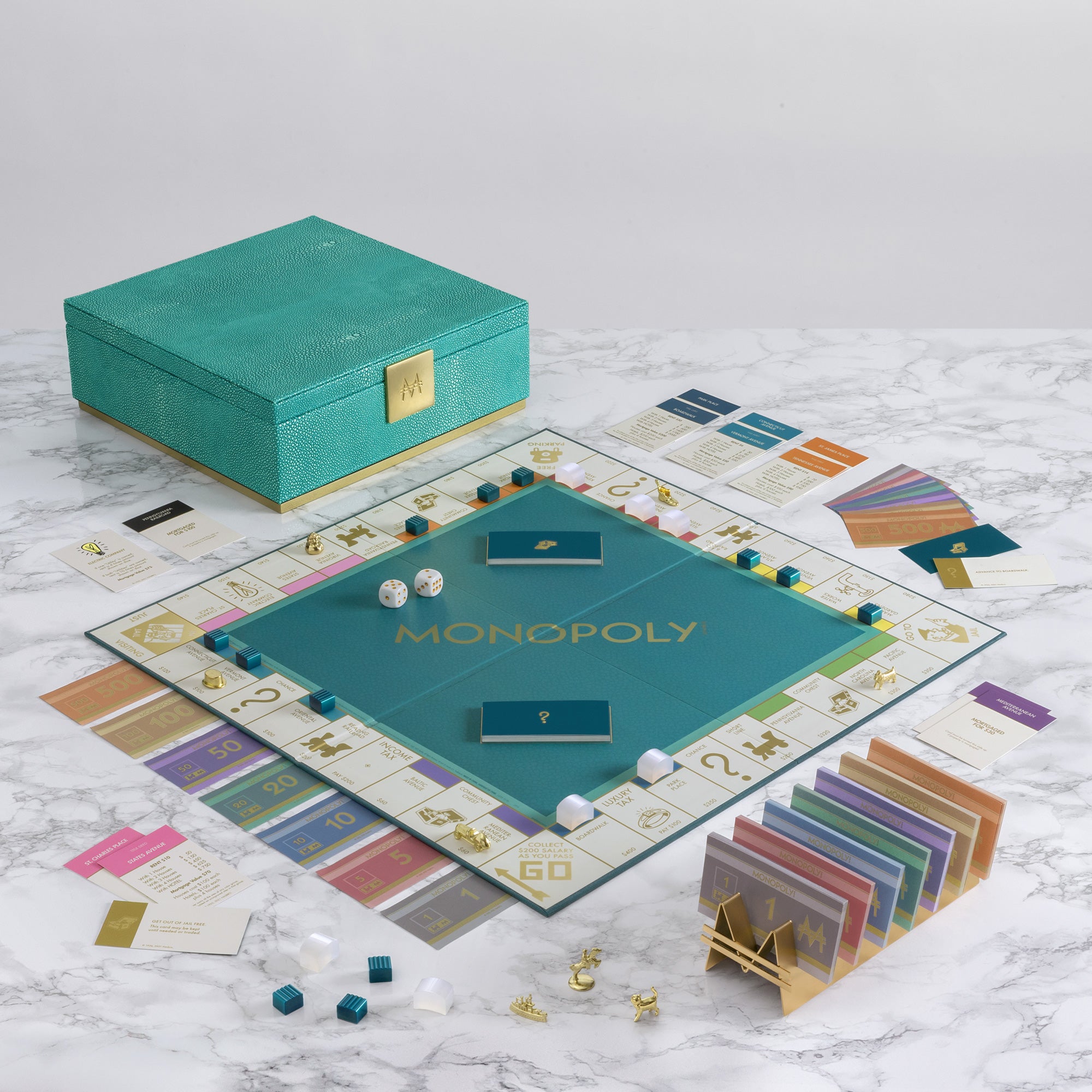 Monopoly game set on a marble surface with a teal box.