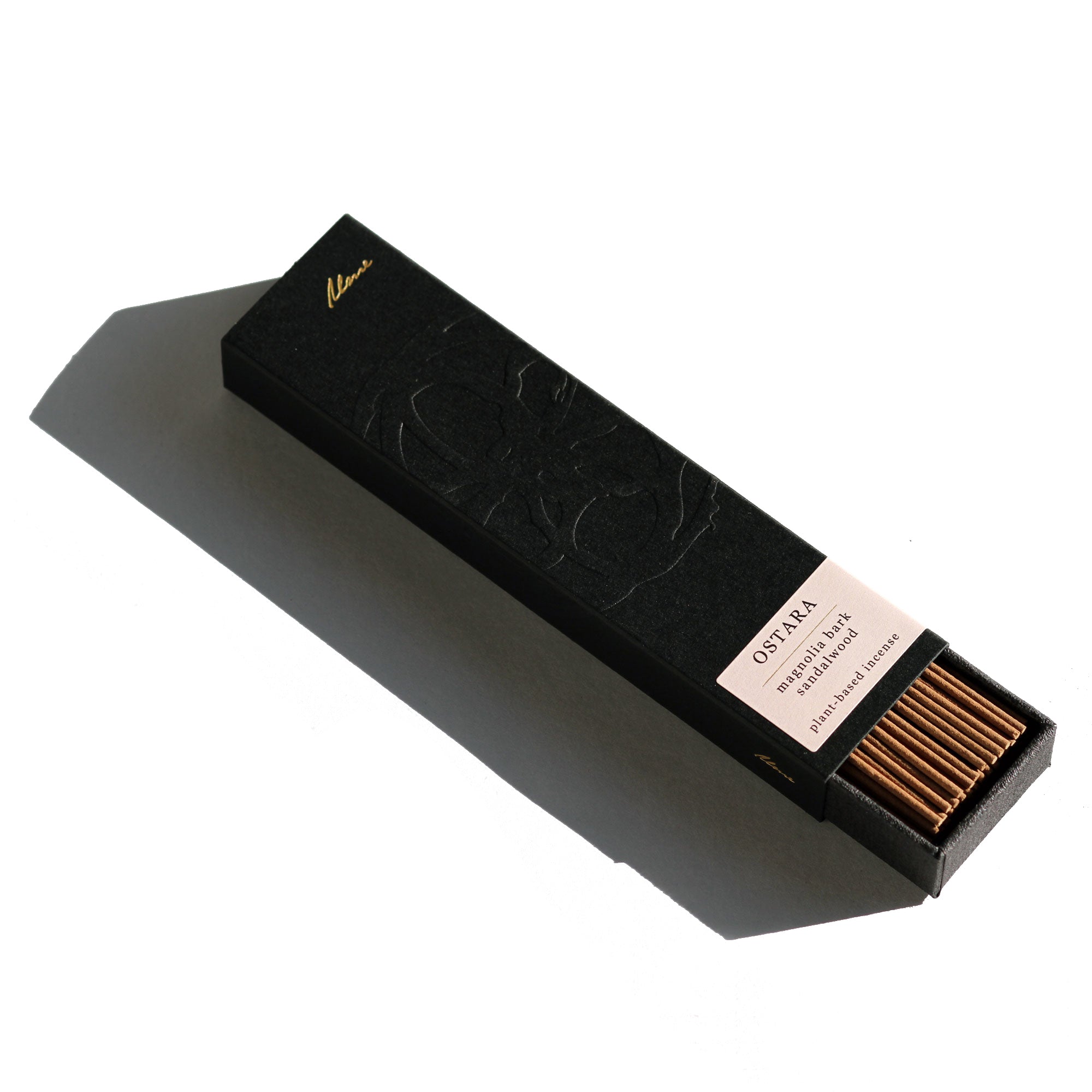 Black tea packaging with visible tea leaves on a white background