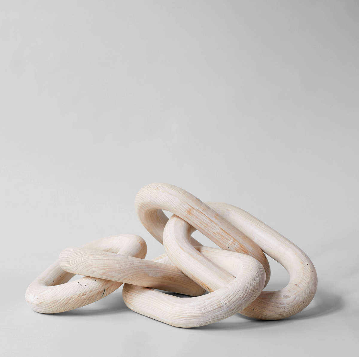 Three wooden rings stacked on a light gray background