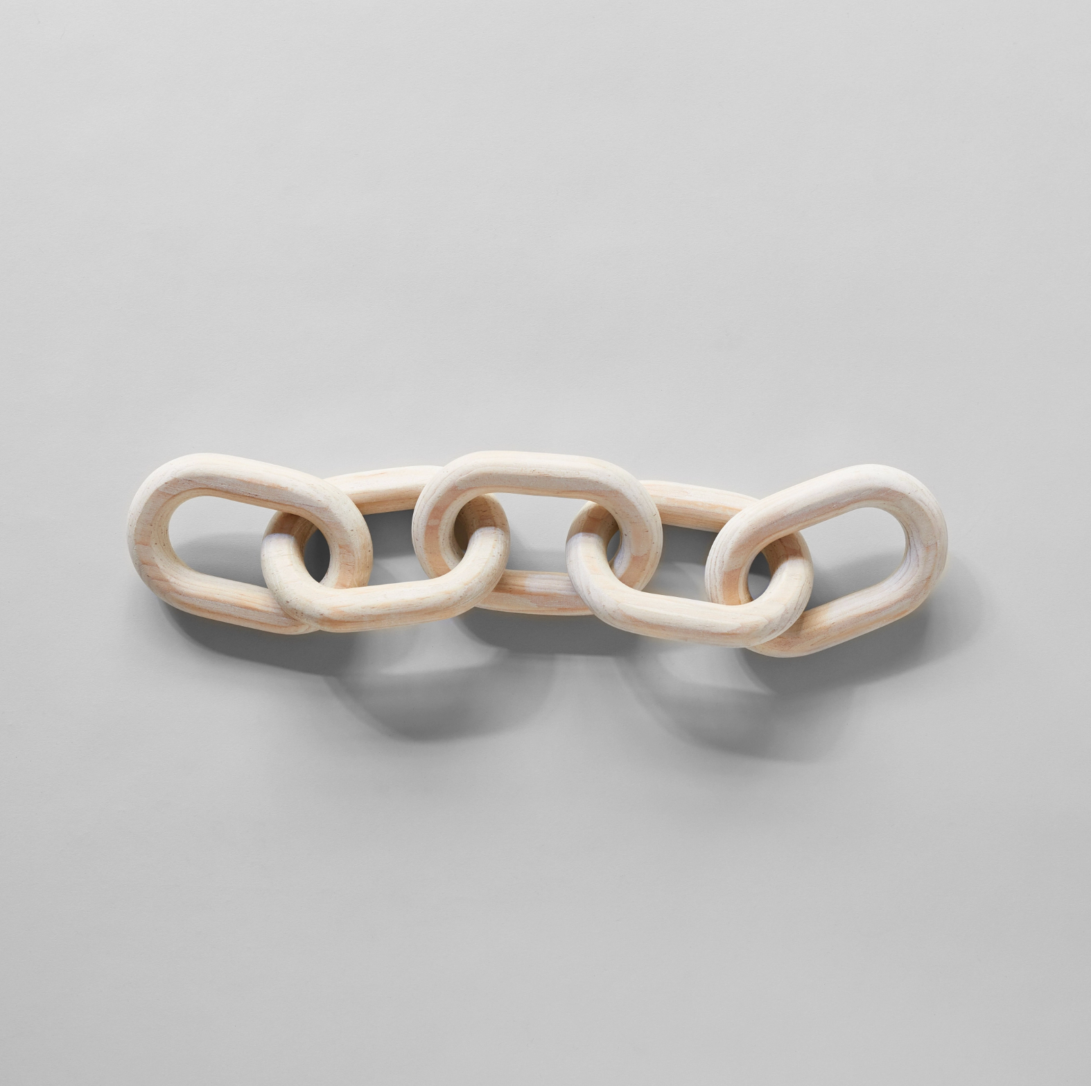 White ceramic chain-like object on a gray background