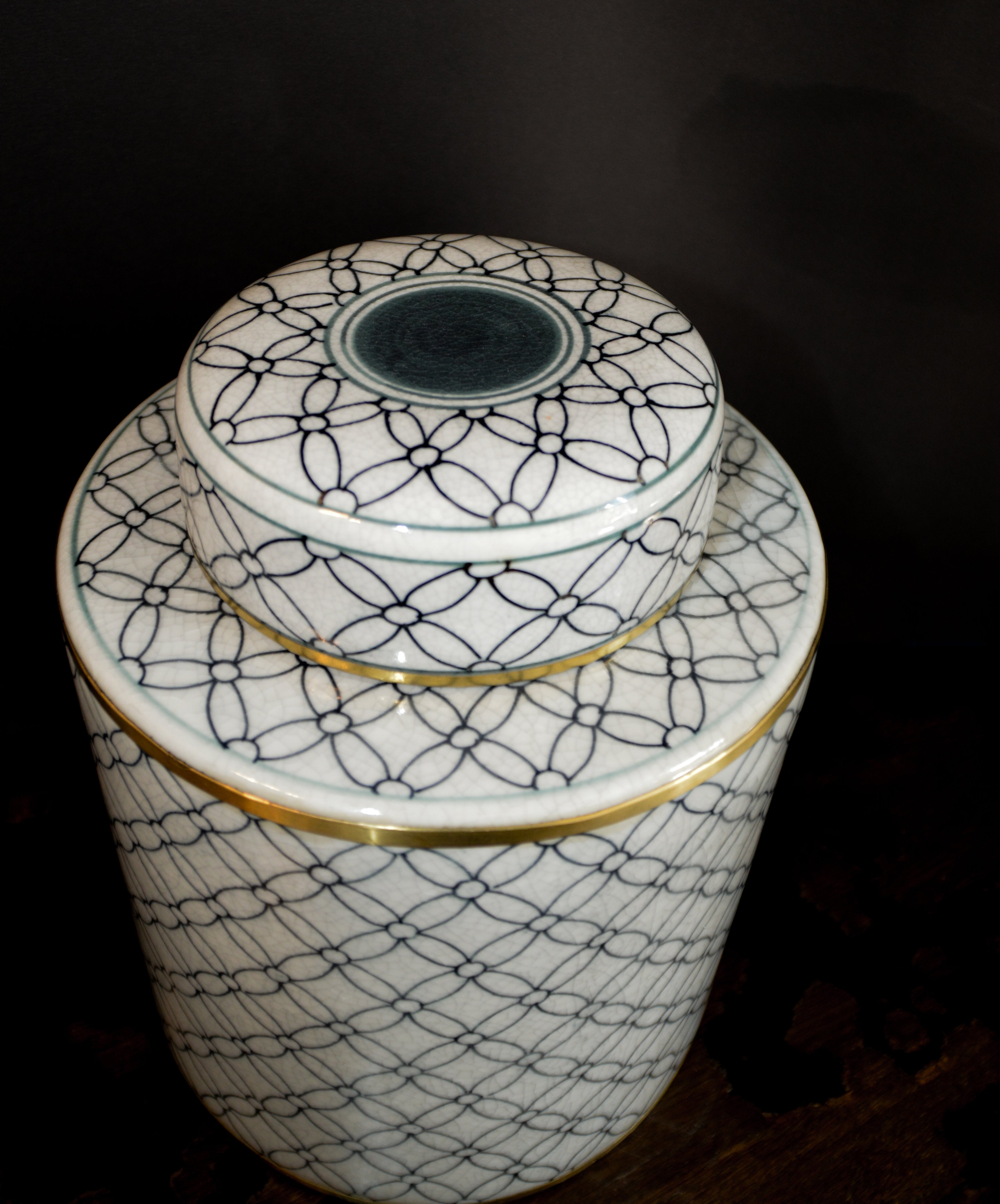 Two ceramic jars with geometric patterns on a dark background