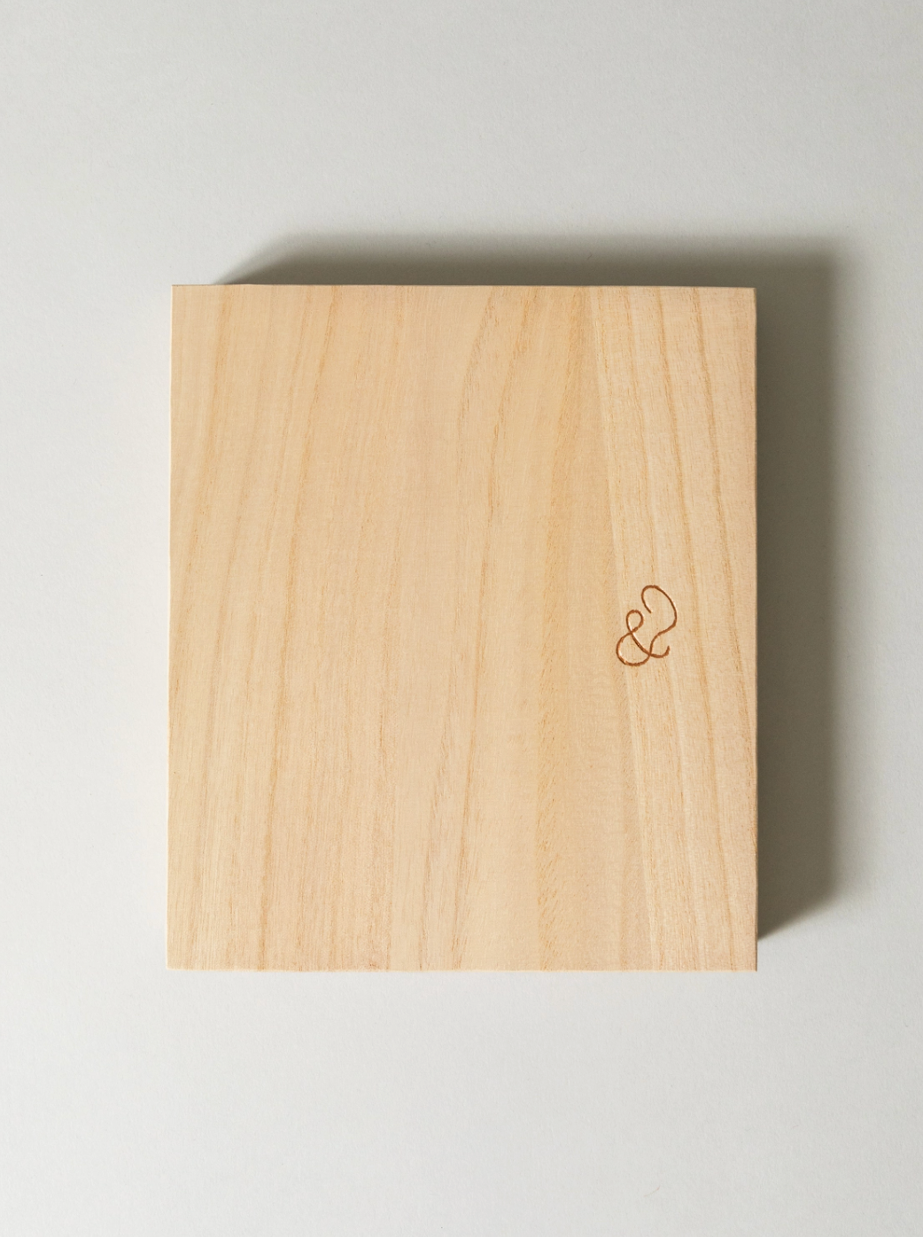 Wooden block with a small logo on a light gray background