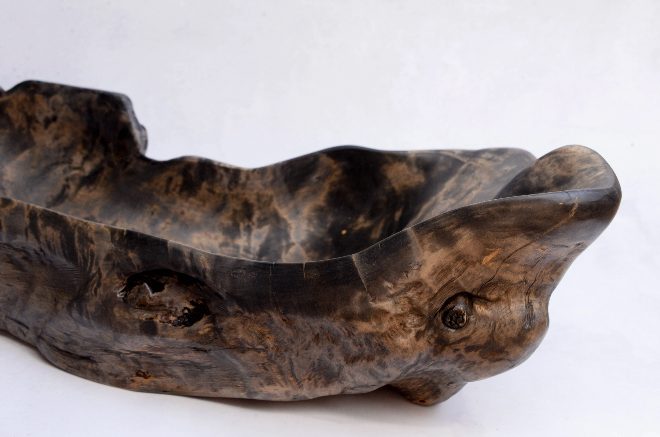 Wooden bowl with a natural, textured surface on a white background