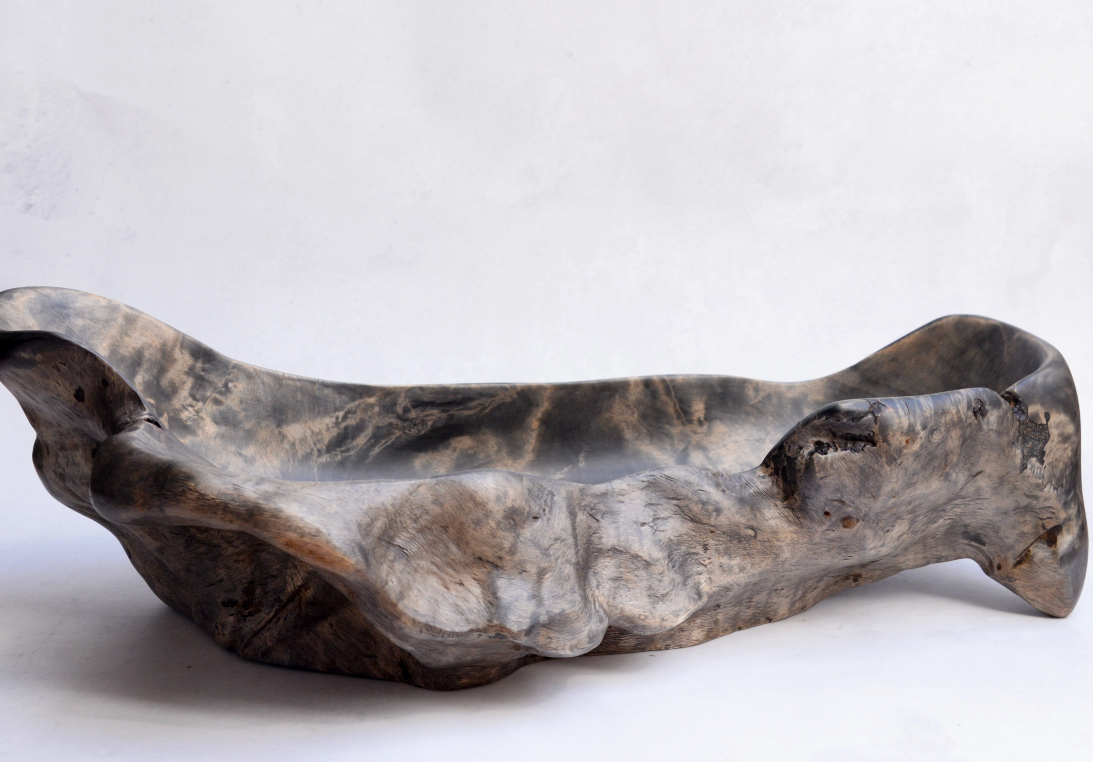 Wooden bowl with a natural, curved design on a white background