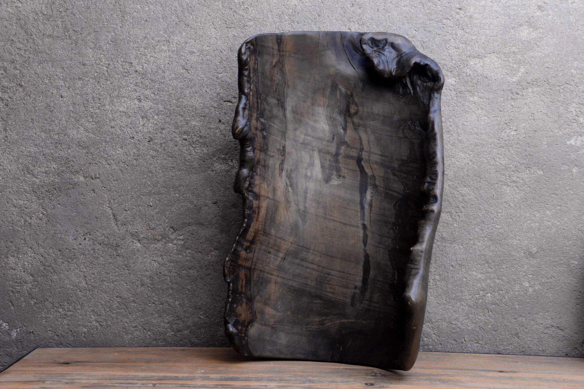 Rustic wooden cutting board on a wooden surface with a gray concrete wall background