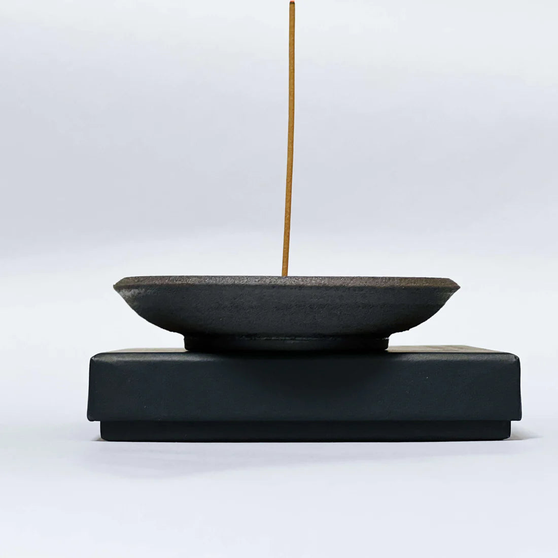 Incense burner with a single incense stick on a white background