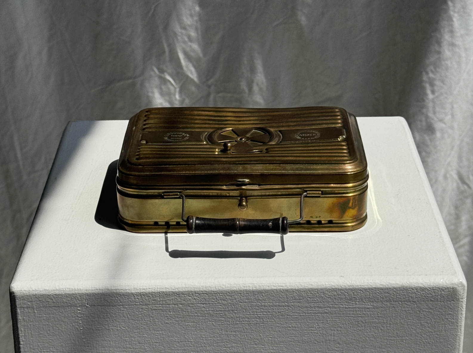 Vintage suitcase on a white pedestal with a plain background