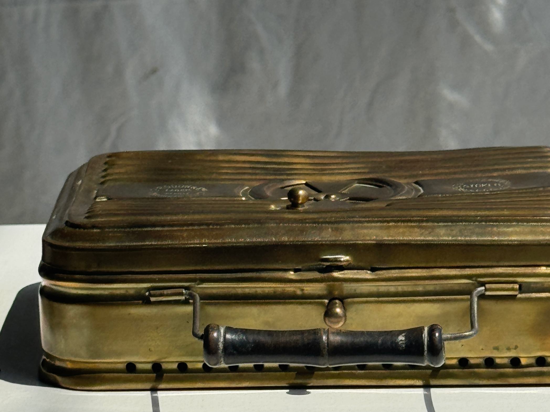 Vintage brass suitcase on a textured gray background