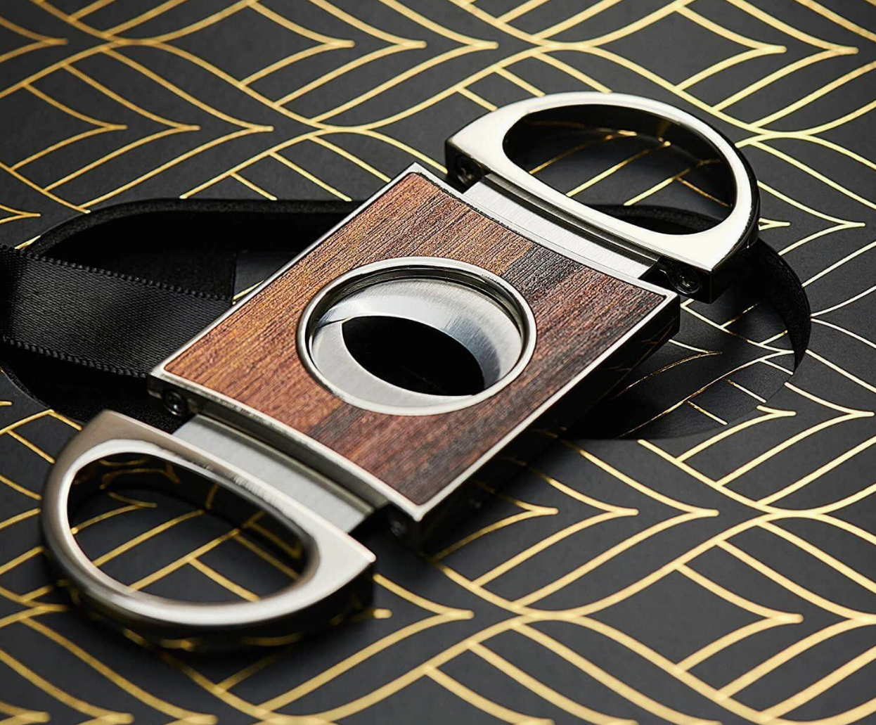 Cigar cutter with wooden and metallic design on a patterned surface