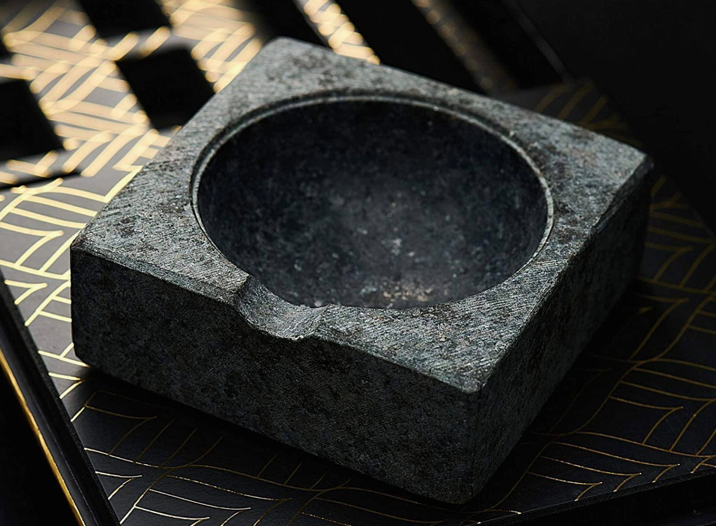 Black stone mortar and pestle on a decorative surface