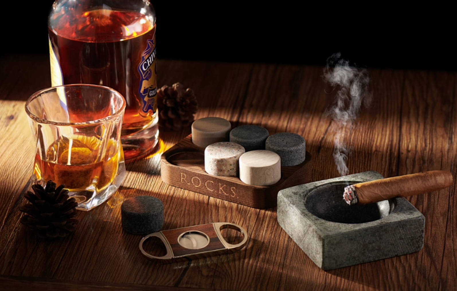 whisky glass, cigar and whisky rocks on a brown table